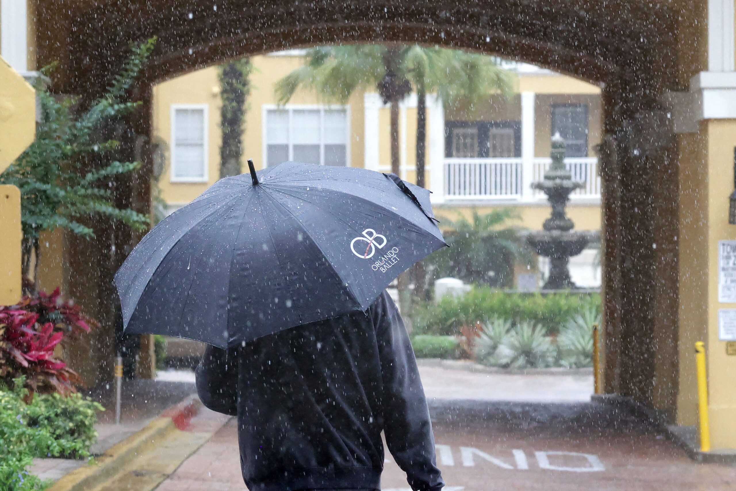 Un residente se cubre en Park North en Cheney Place en North Orange Avenue en Orlando, el lunes 12 de mayo de 2025. Se pronostica que la lluvia del lunes dará paso a condiciones más secas por el resto de la semana. (Joe Burbank/Orlando Sentinel)