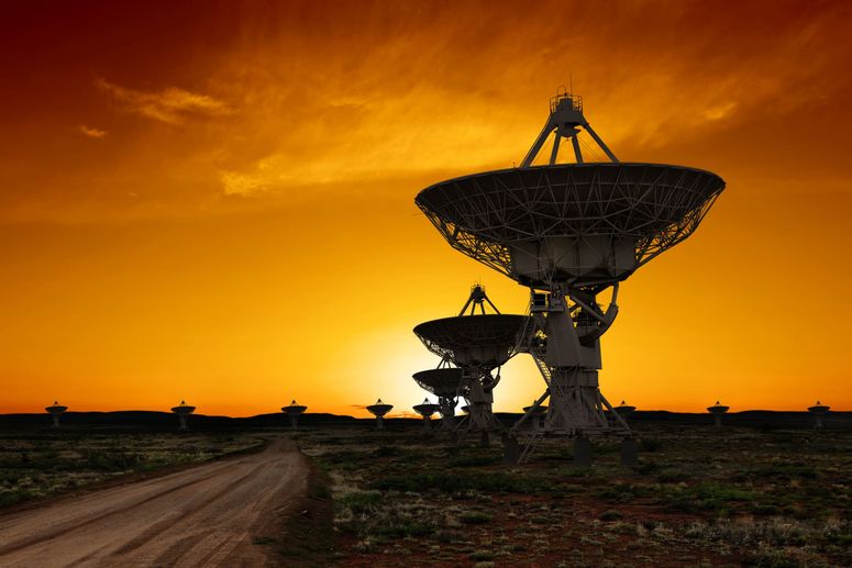 Siluetas de radiotelescopios al atardecer.