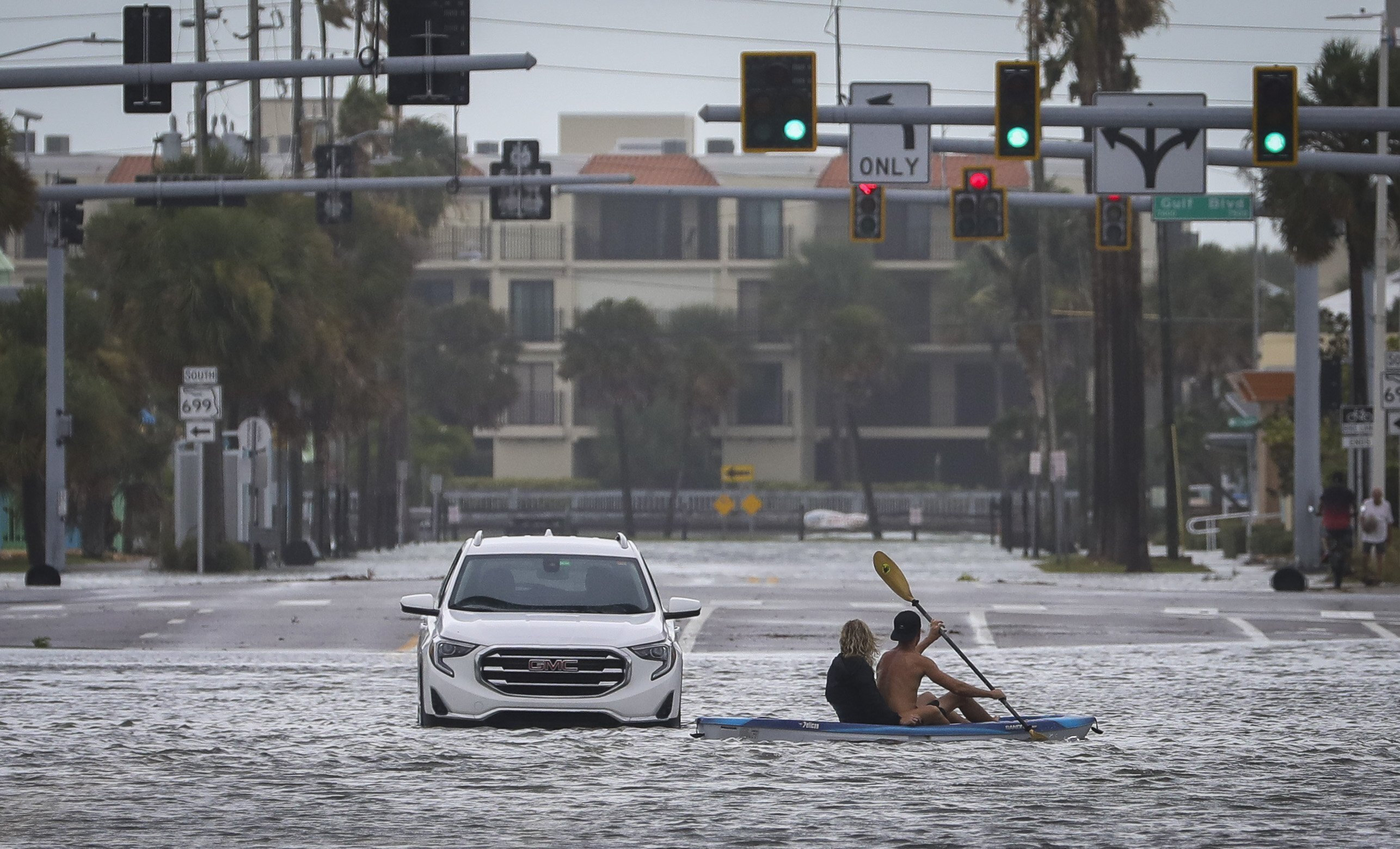 La gente de Kayak pasa por un vehículo de abandono en la intersección de Boca Ciega Drive y Pasadena Avenue en St. Pete Beach, sintiendo los efectos del huracán Idalia el miércoles 30 de agosto de 2023. Idalia tocó tierra en el norte de Florida como una tormenta de categoría 3 (Chris Urso/Tampa Bay Times a través de AP)