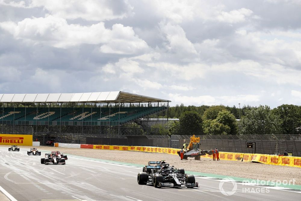 Lewis Hamilton, Mercedes F1 W11, Valtteri Bottas, Mercedes F1 W11, and Max Verstappen, Red Bull Racing RB16, as they pass the crashed car of Kevin Magnussen, Haas VF-20