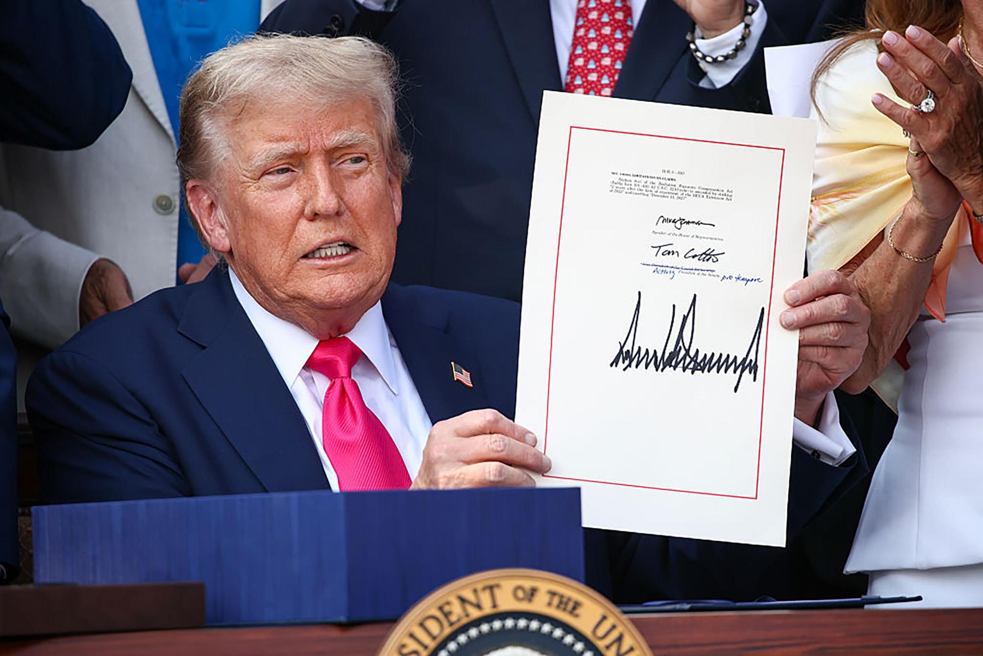 El presidente de los Estados Unidos, Donald Trump, unido por legisladores republicanos, firma el único acto de Big Beautiful Bill durante un picnic familiar militar del Día de la Independencia en el South Lawn de la Casa Blanca el 4 de julio de 2025, en Washington, DC. (Samuel Corum/Getty Images North America/TNS)