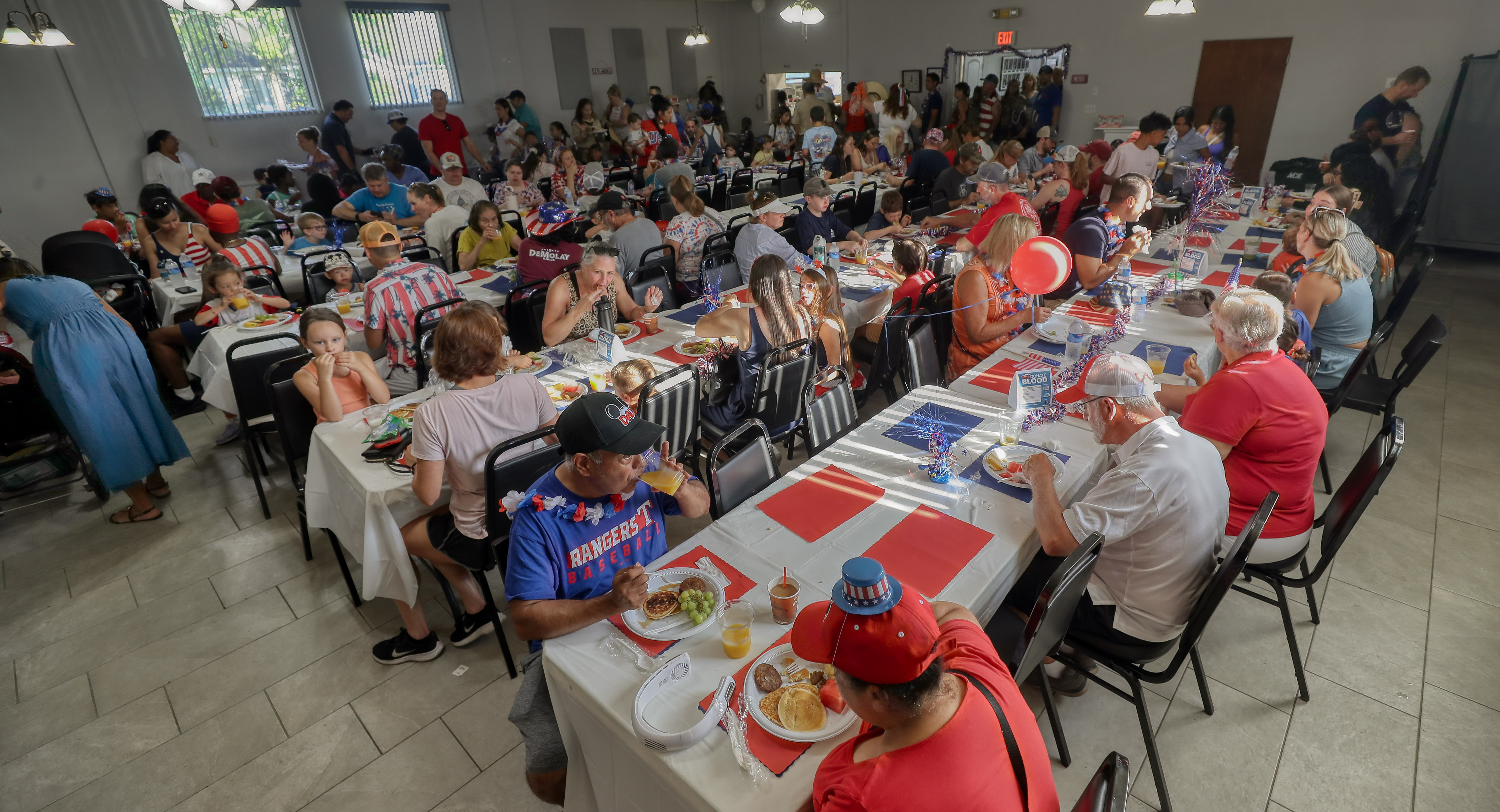 La gente disfruta del desayuno antes del desfile en el Winter Garden Masonic Lodge All American Kids Parade & Breakfast en el centro de Winter Garden el viernes (Ricardo Ramirez Buxeda/Orlando Sentinel)