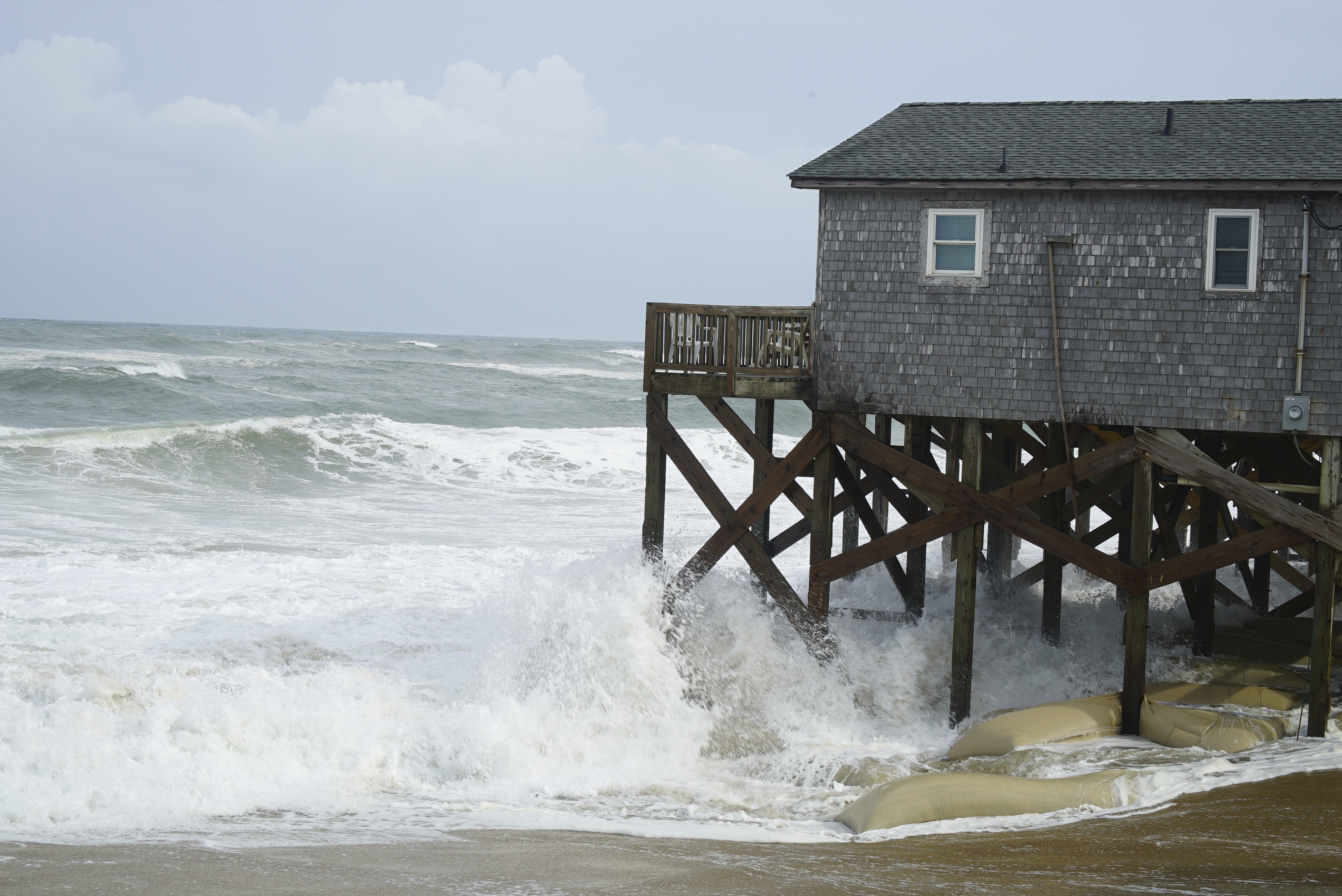 Ondas del huracán Erin Crash contra los pilotes de arena de un edificio en Buxton, Carolina del Norte, el miércoles 20 de agosto de 2025. (AP Photo/Allen G. Breed)