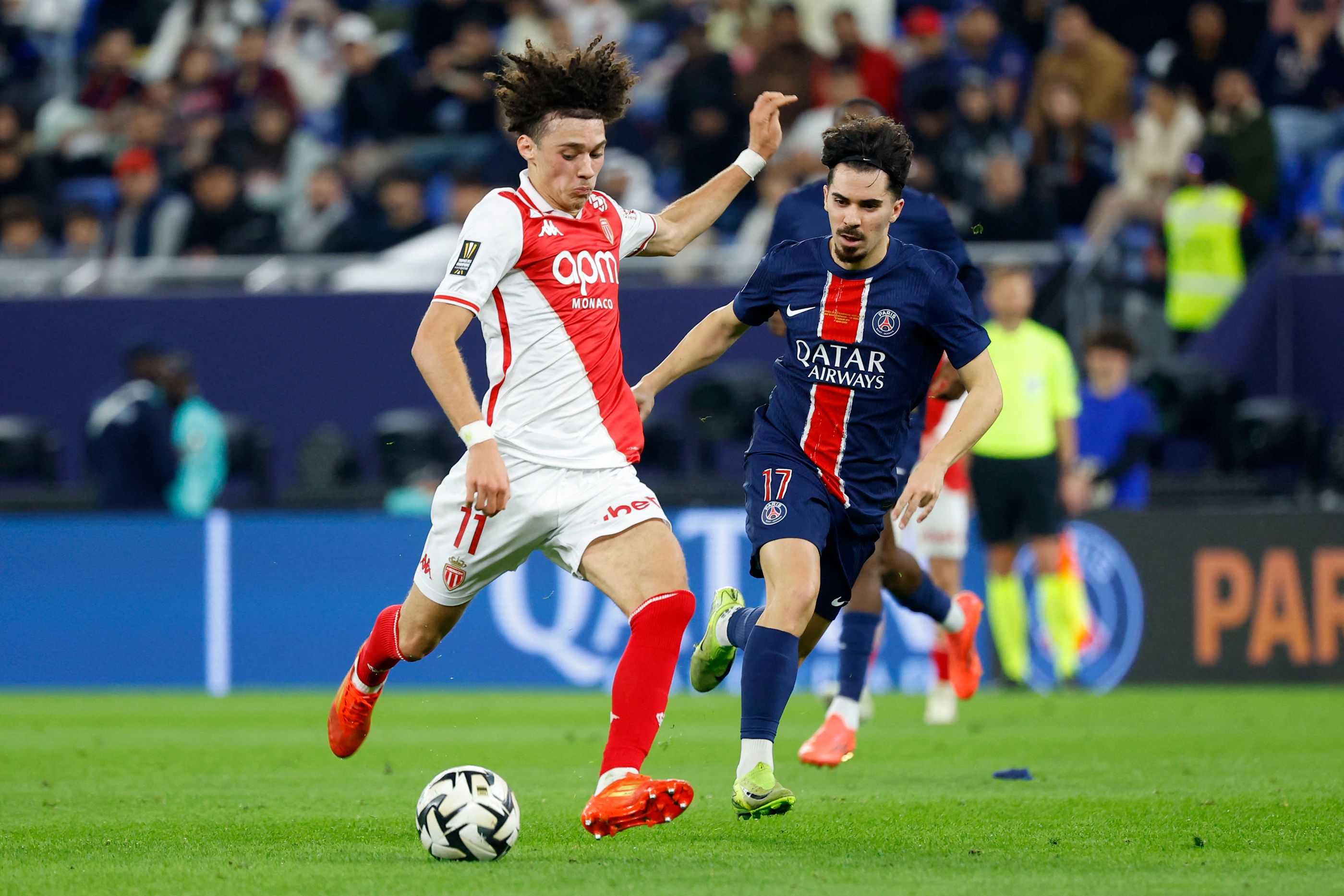Monaco's French midfielder #11 Maghnes Akliouche runs with the ball past Paris Saint-Germain's Portuguese midfielder #17 Vitinha during the French Champions' Trophy (Trophee des Champions) final football match between Paris Saint-Germain (PSG) and AS Monaco (ASM) at the Stadium 974 in Doha on January 5, 2025. (Photo by KARIM JAAFAR / AFP)