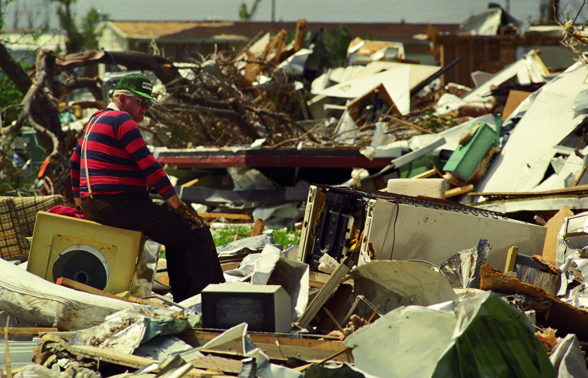 El huracán Andrew destruyó más de 25,000 casas en el condado de Miami-Dade cuando llegó el 24 de agosto de 1992. Bill Edwards, mostrado dos semanas después de la tormenta, revisó lo que alguna vez fue su hogar en el Parque de Remolques de Desoto en granja. (Archivo South Florida Sun Sentinel)