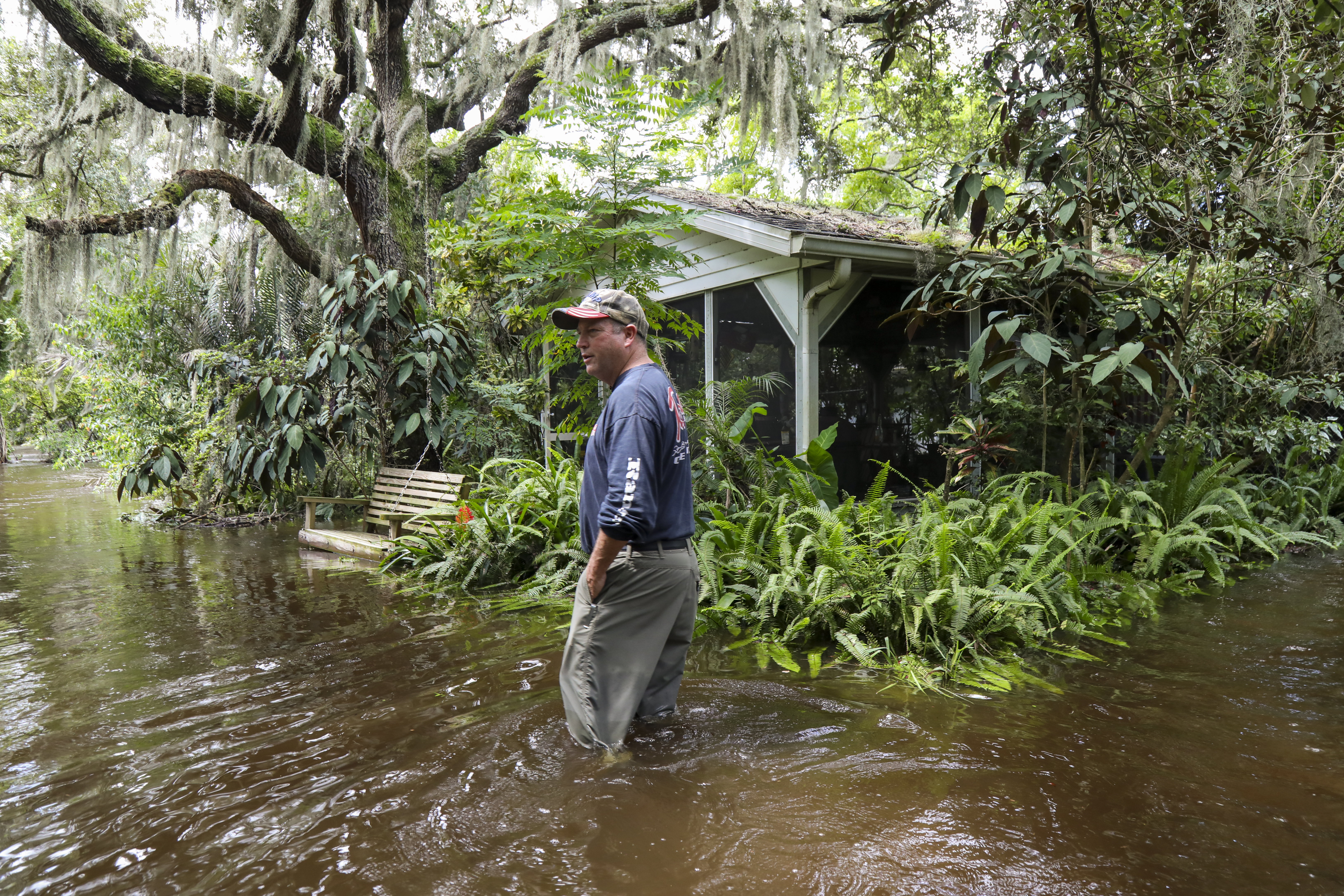 Kurt McAnly, de 56 años, de Riverview, Florida, camina alrededor del patio trasero de su casa inundada el martes 6 de agosto de 2024. La casa de McAnly se inundó en las primeras horas de la mañana del martes, lo que lo obligó a él y a sus dos perros a evacuar alrededor de las 4 am McAnly estima que el agua aumentó alrededor de 24-30 pulgadas de altura en su casa ese día como resultado de huracane Deby. (Dylan Townsend/TNS/Tampa Bay Times)