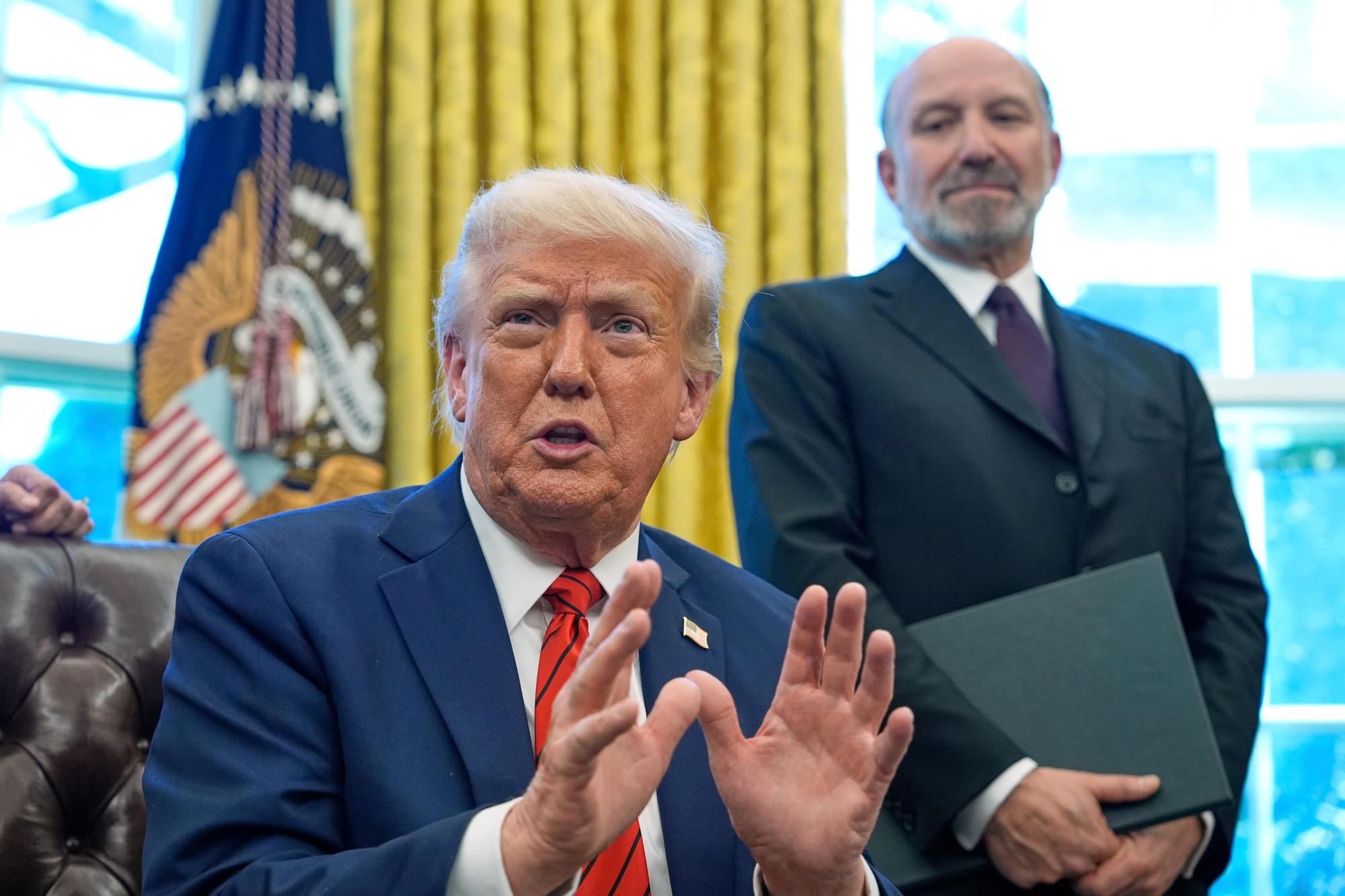 El presidente Donald Trump habla mientras firma órdenes ejecutivas en la Oficina Oval de la Casa Blanca, el jueves 17 de abril de 2025, en Washington, como escucha el secretario de Comercio Howard Lutnick. (AP Photo/Alex Brandon)