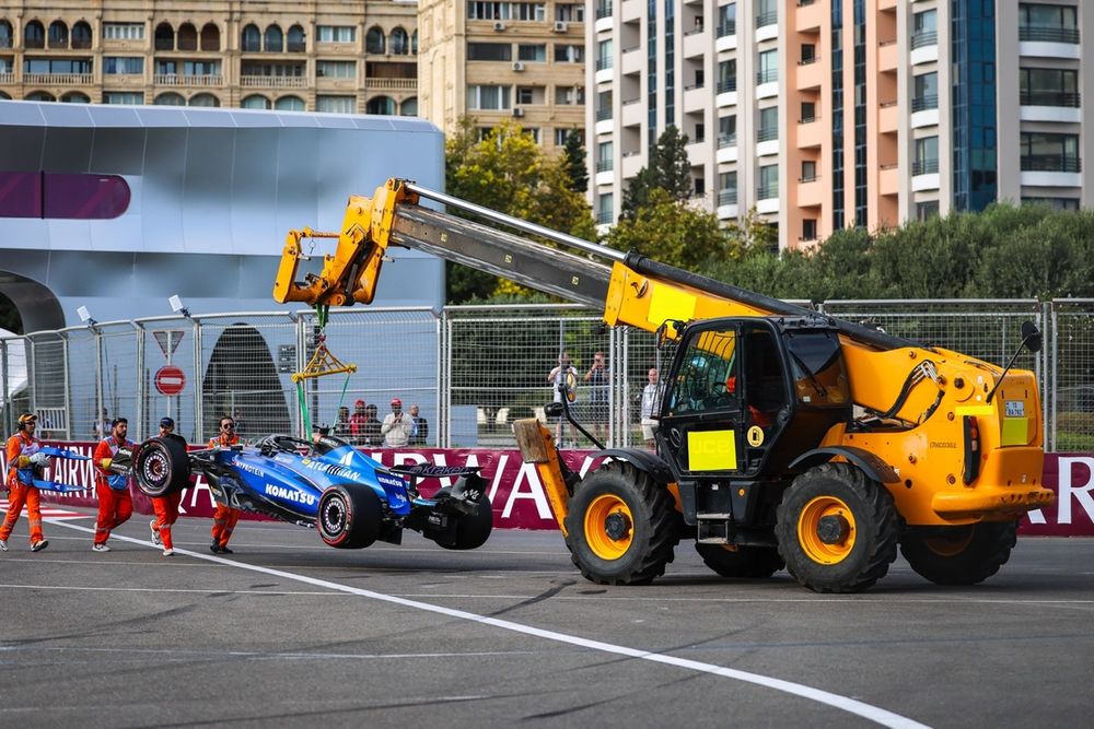 El coche de Albon es retirado con una grúa tras su golpe en el muro en la curva 1.
