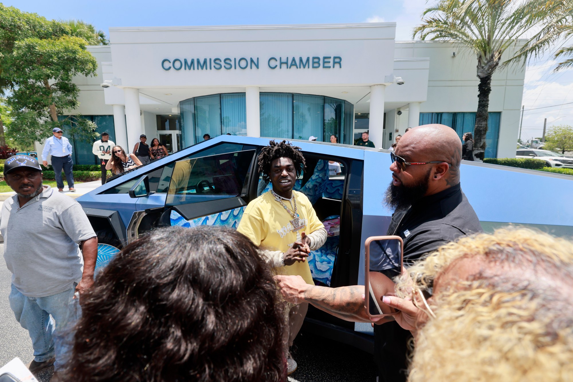 Kodak Black se prepara para abandonar la reunión de la Comisión de la Ciudad de Pompano Beach después de recibir su clave honoraria de la ciudad el 8 de julio de 2025. El rapero está acusado de abusar de la madre de dos de sus hijos y no pagar la manutención de los hijos en medio de un desaprobado de custodia contenciosa que se desarrolla en el Tribunal del Condado de Broward, según informes policiales y documentos de la corte. (Mike Stocker/South Florida Sun Sentinel)