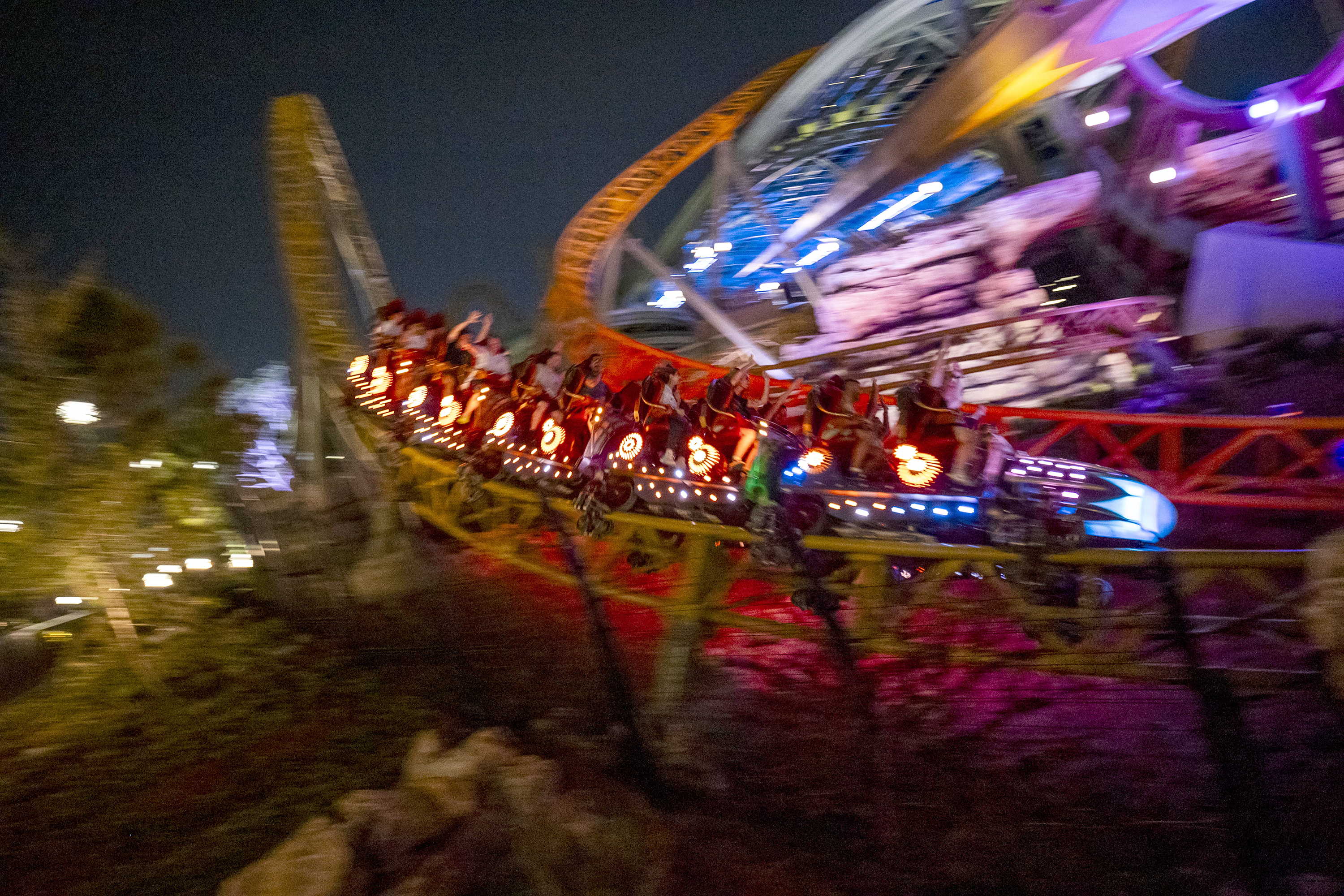 Los invitados llevan un paseo en la montaña rusa gemela de Stardust Racers en la noche en Epic Universe el 21 de abril de 2025. (Patrick Connolly/The Orlando Sentinel)