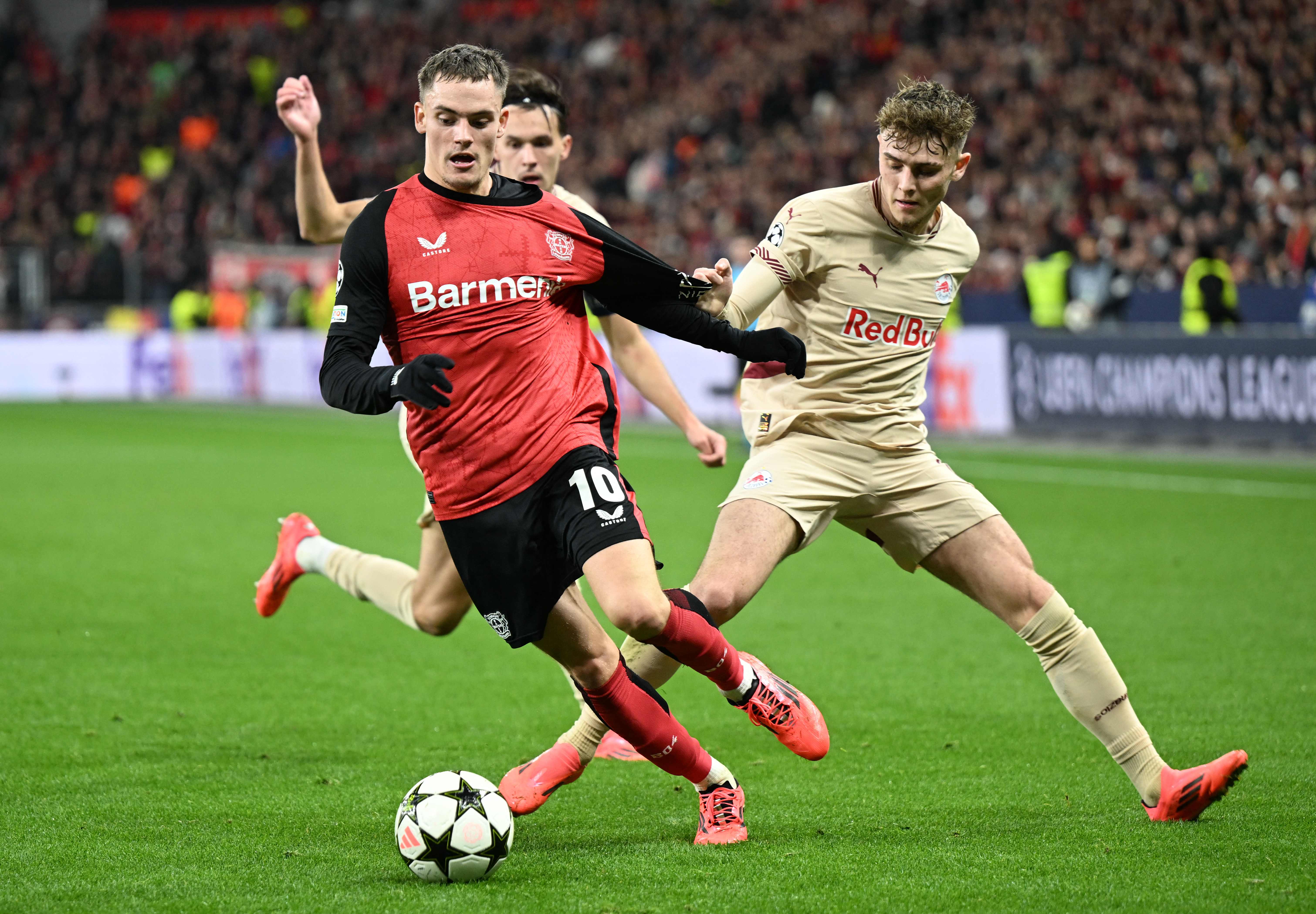 Bayer Leverkusen's German midfielder #10 Florian Wirtz (L) and Salzburg's English midfielder #10 Bobby Clark vie for the ball during the UEFA Champions League football match Bayer 04 Leverkusen vs FC Salzburg in Leverkusen, western Germany on November 26, 2024. (Photo by INA FASSBENDER / AFP)