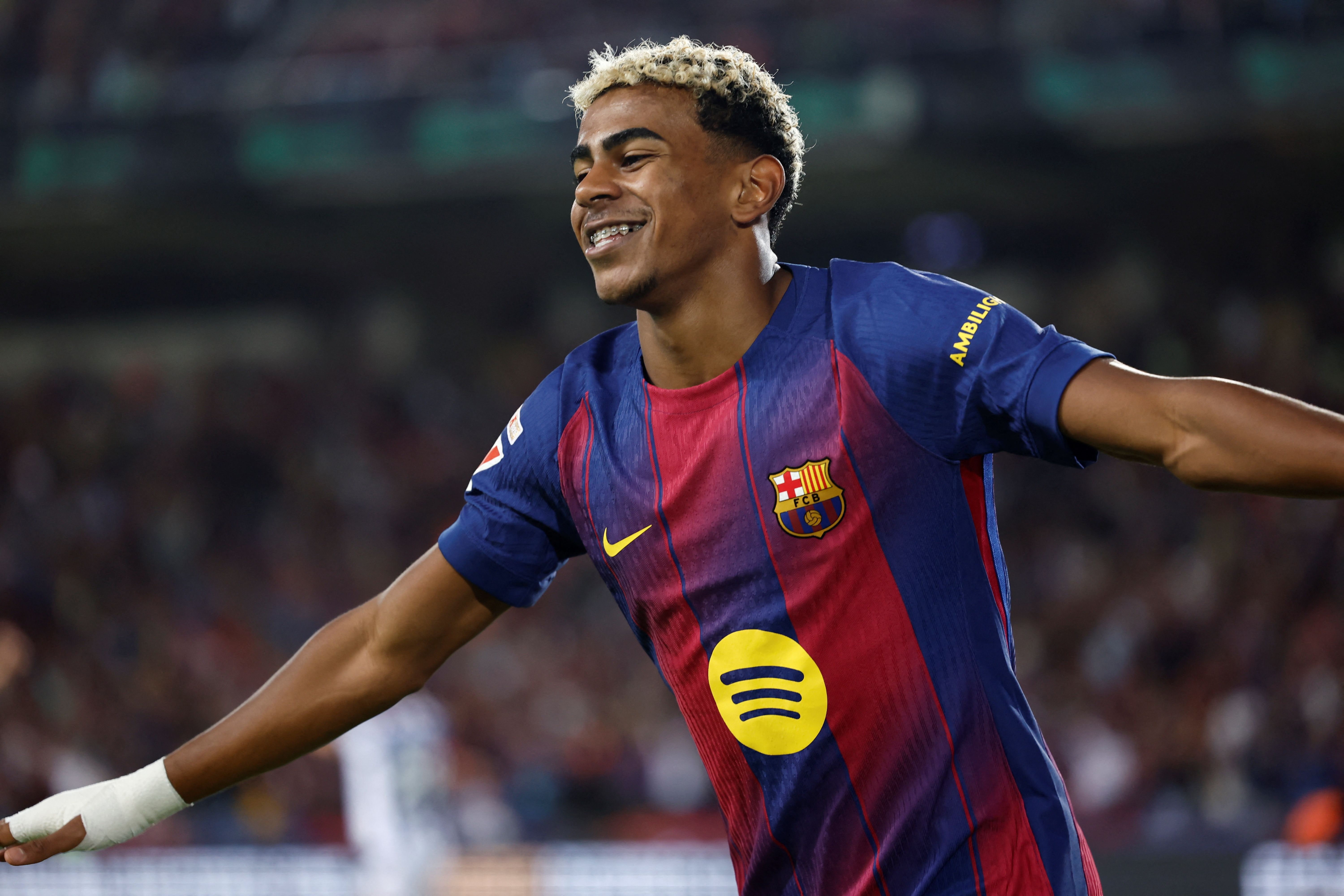 Barcelona's Spanish forward #10 Lamine Yamal reacts after Barcelona's Polish forward #09 Robert Lewandowski scored his team's second goal during the Spanish league football match between FC Barcelona and Real Sociedad at the Estadi Olimpic Lluis Companys in Barcelona on September 28, 2025. (Photo by Josep LAGO / AFP)