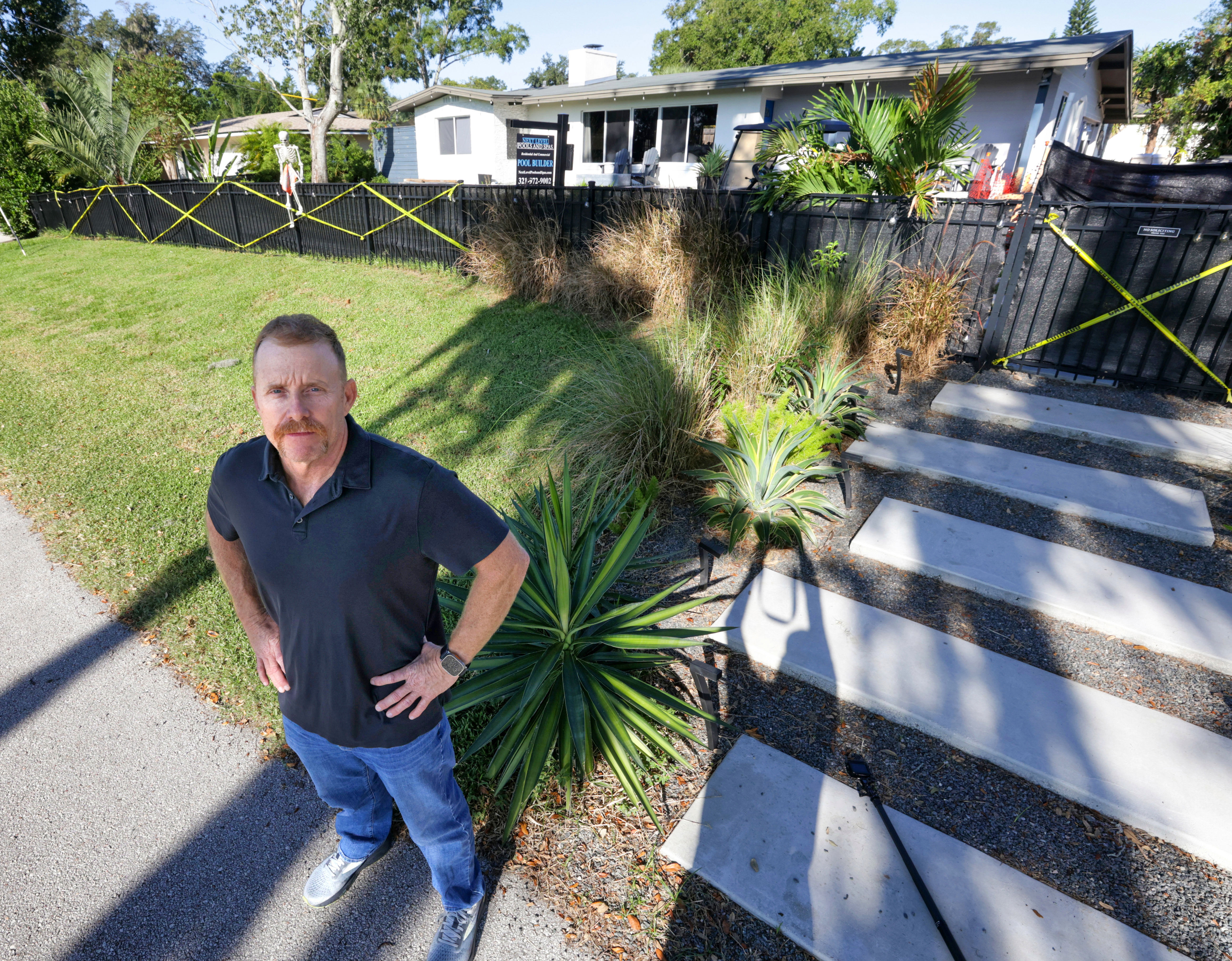 Jason White, residente del condado de Seminole, se encuentra frente al patio delantero de su vecino en construcción en Lake Shore Drive en la zona no incorporada de Maitland, el miércoles 29 de octubre de 2025. Los vecinos, incluido White, se opusieron cuando el residente Robert Taylor comenzó la instalación de una piscina en el patio frente a la calle. (Joe Burbank/Orlando Sentinel)