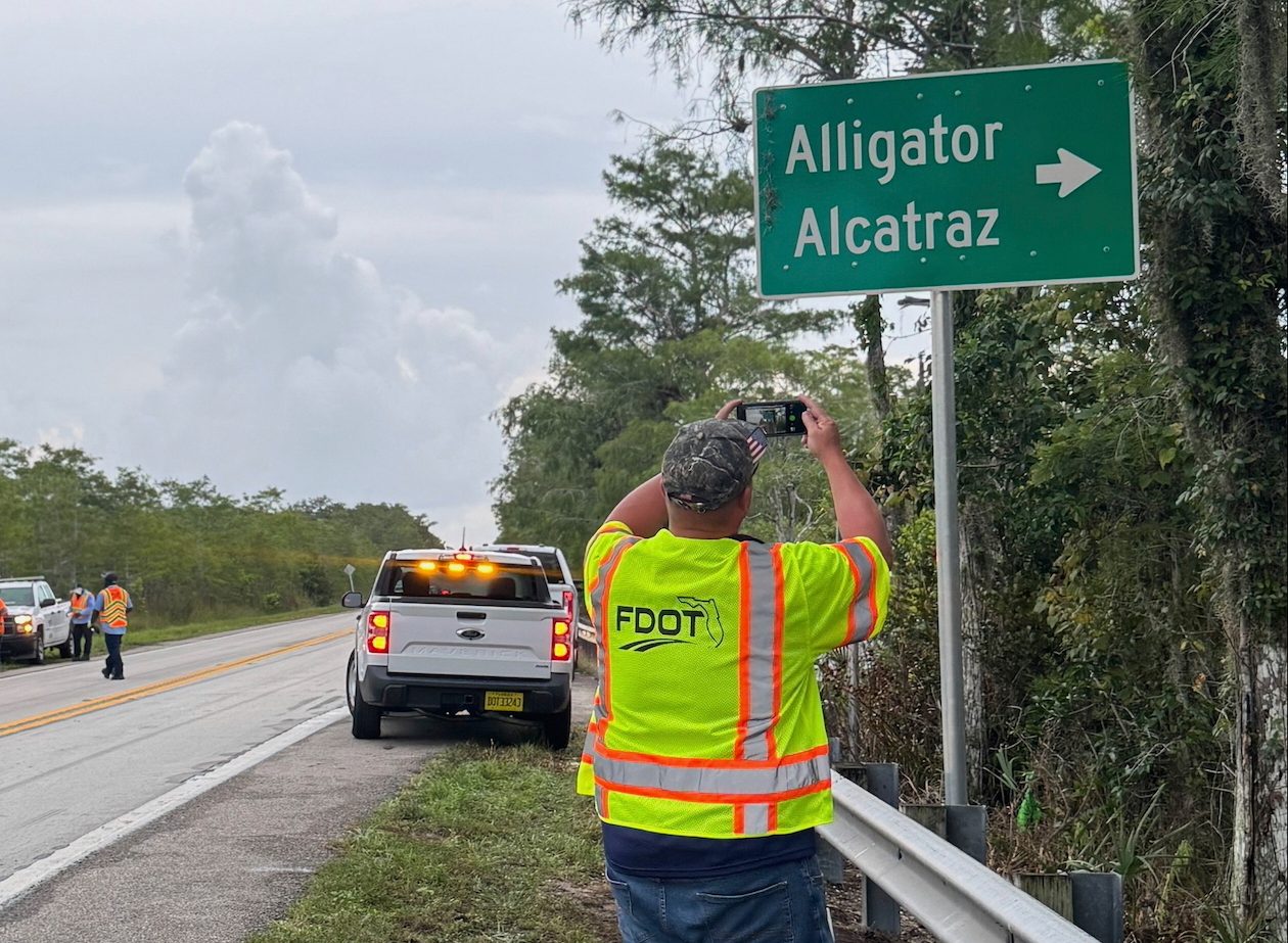 Estados Unidos-Inmigración-Florida-Detenidos En esta fotografía proporcionada por Jessica Namath, un hombre toma una fotografía de una nueva señal en la carretera con la etiqueta