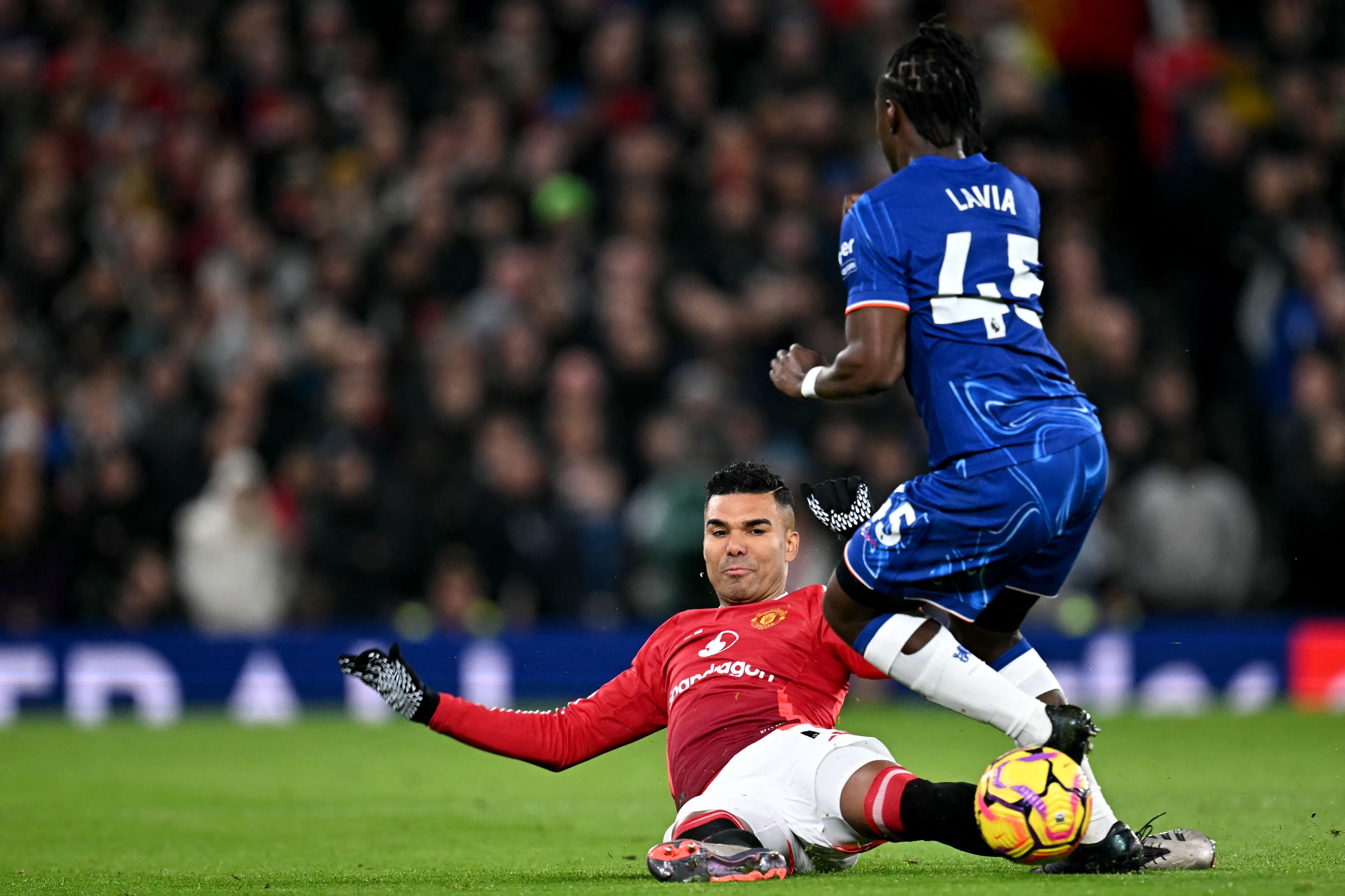 Manchester United's Brazilian midfielder #18 Casemiro tackles Chelsea's Belgian midfielder #45 Romeo Lavia during the English Premier League football match between Manchester United and Chelsea at Old Trafford in Manchester, north west England, on November 3, 2024. (Photo by Paul ELLIS / AFP) / RESTRICTED TO EDITORIAL USE. No use with unauthorized audio, video, data, fixture lists, club/league logos or 'live' services. Online in-match use limited to 120 images. An additional 40 images may be used in extra time. No video emulation. Social media in-match use limited to 120 images. An additional 40 images may be used in extra time. No use in betting publications, games or single club/league/player publications. / 