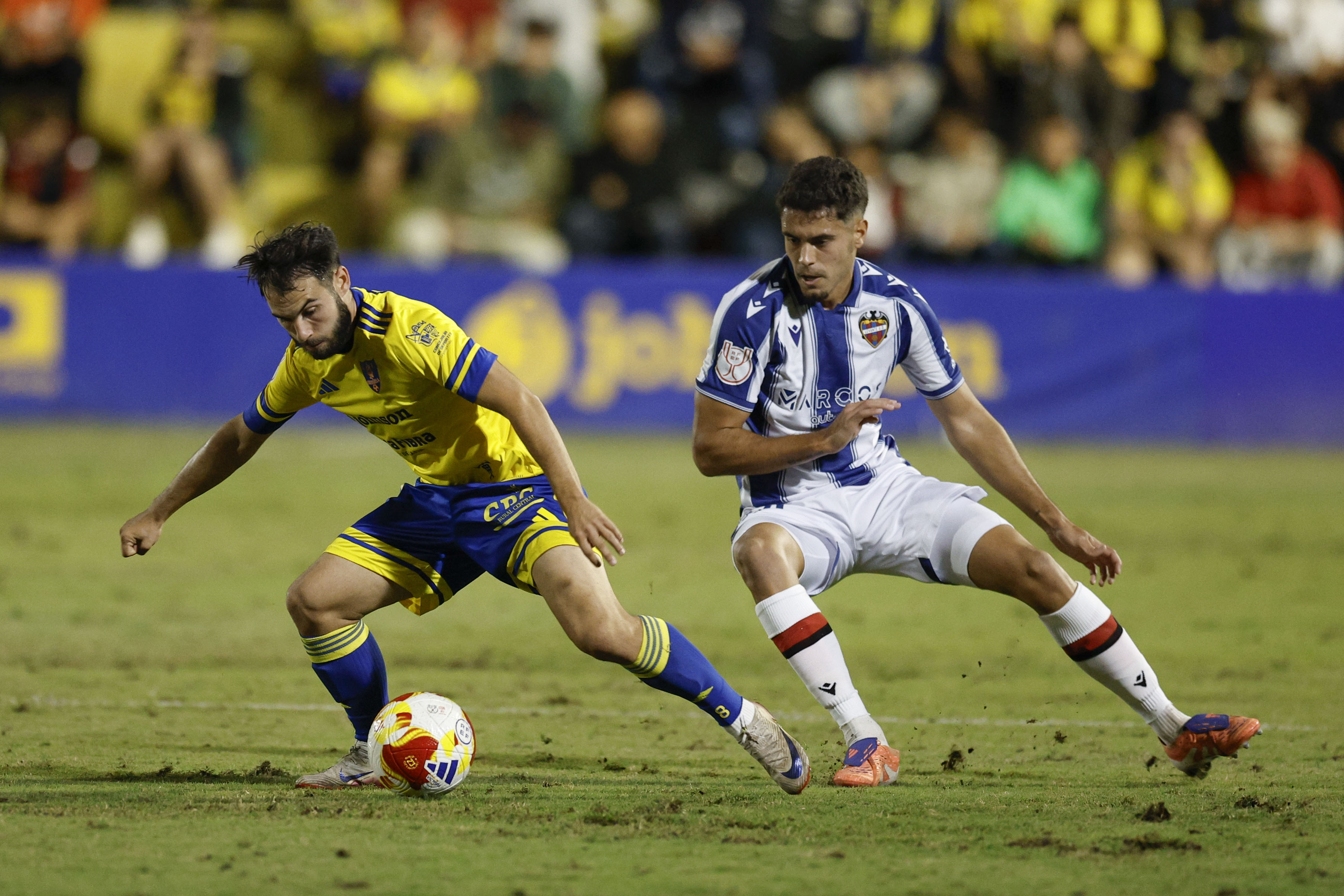 ORIHUELA (ALICANTE), 30/10/2025.- El defensa del Levante Jorge Cabello (d) pelea un balón con José Alonso Lara, delantero del Orihuela, durante el partido de la primera ronda de la Copa del Rey de fútbol celebrado este jueves en el Estadio Municipal Los Arcos. EFE/ Kai Forsterling
