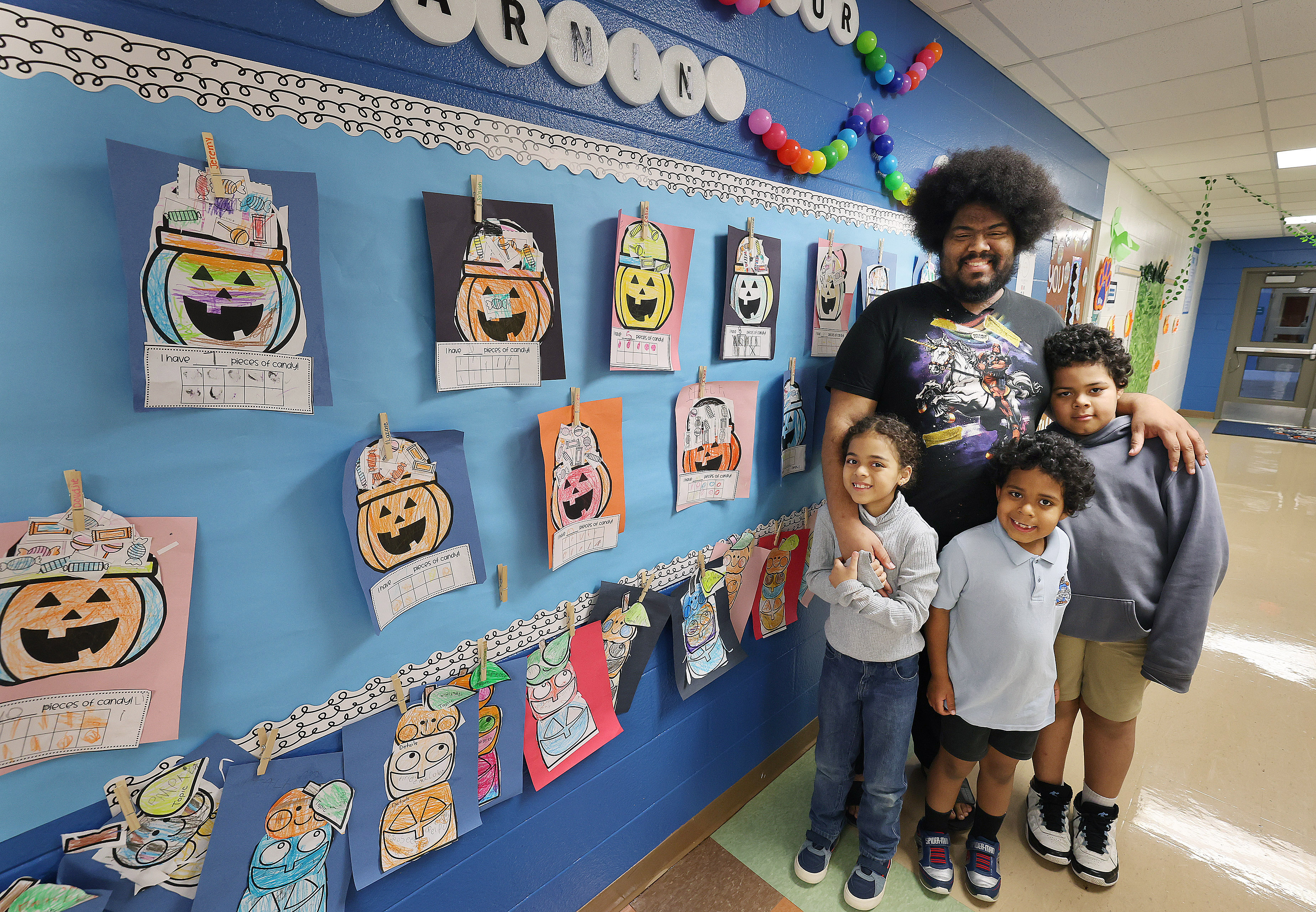Preston Davis, arriba, y sus hijos (desde la izquierda): Anastasia, Cassius y Leonardo en la foto de la escuela primaria Orange Center en Orlando el jueves 13 de noviembre de 2025. (Stephen M. Dowell/Orlando Sentinel)