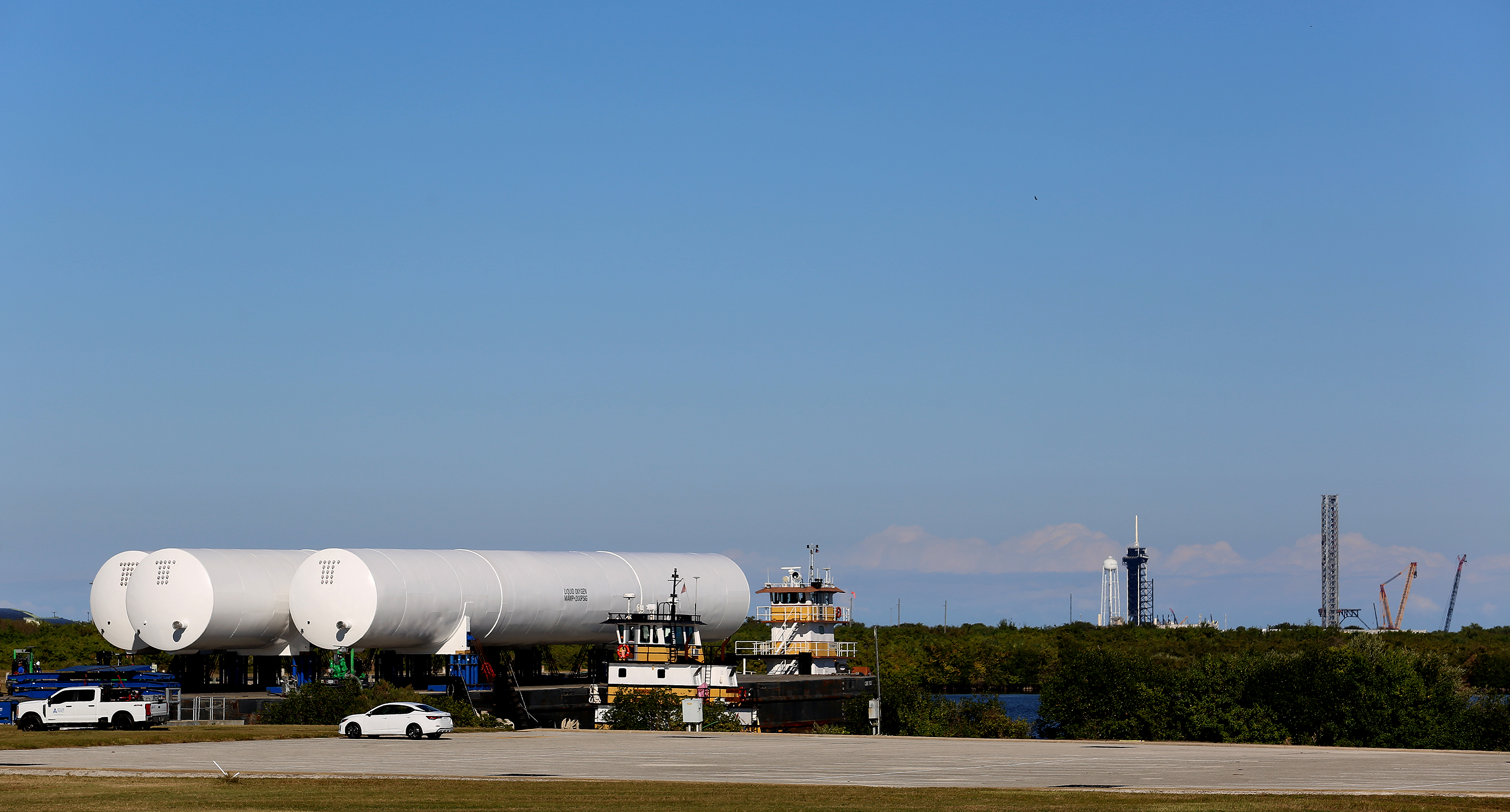 Un trío de tanques de oxígeno líquido llegó al Centro Espacial Kennedy el martes 18 de noviembre de 2025 para SpaceX mientras continúa la construcción de lanzamientos ampliados, incluida una nueva Starship y una torre Super Heavy en la plataforma de lanzamiento 39-A de KSC, que se ve al fondo. (Richard Tribou/Orlando Sentinel)