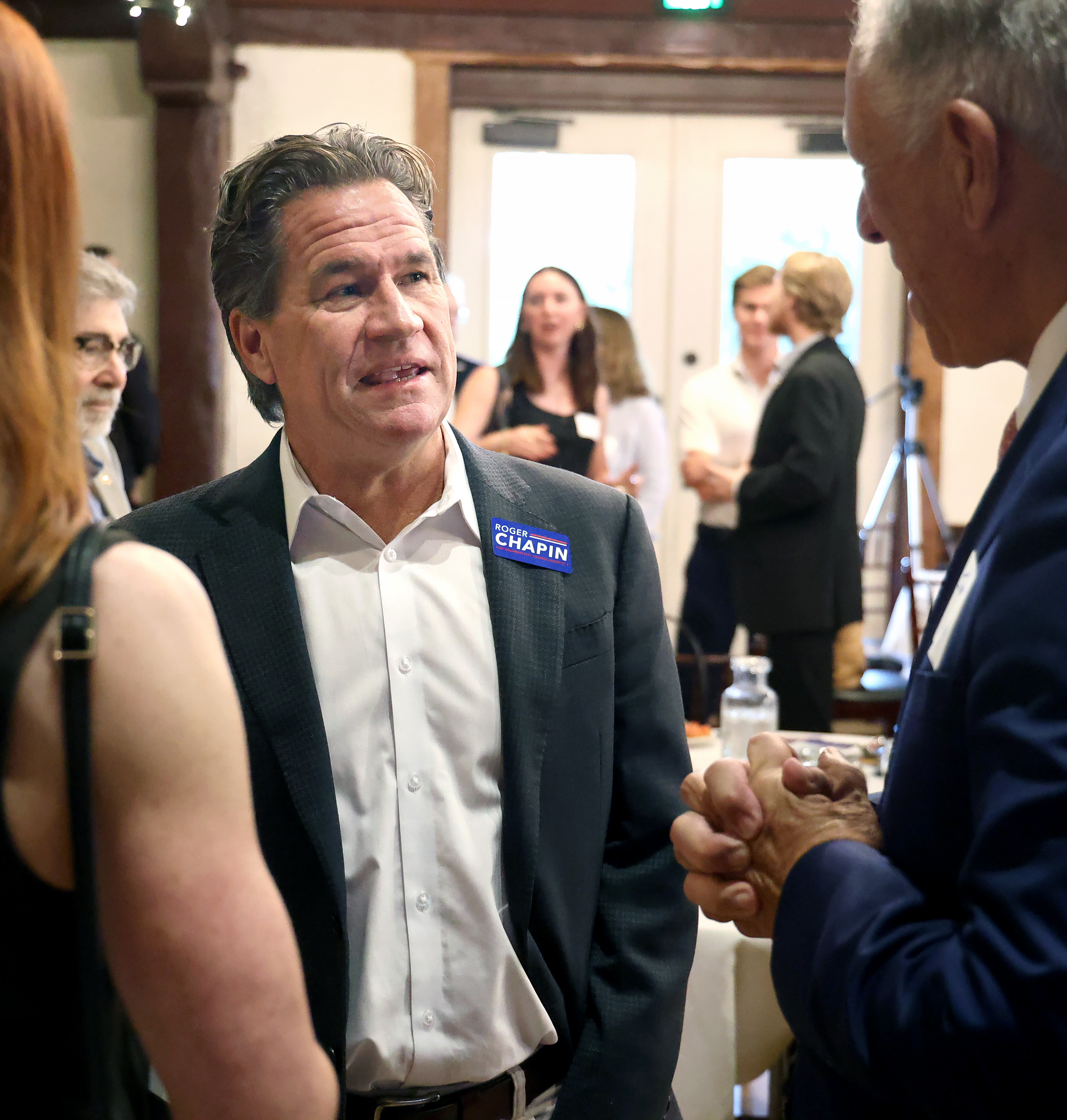 El candidato al Concejo Municipal de Orlando, Roger Chapin, conversa con Jim Gray, a la derecha, antes del inicio de los debates organizados por el Tiger Bay Club de Florida Central, en el campo de golf Dubsdread, el martes 30 de septiembre de 2025. (Joe Burbank/Orlando Sentinel)