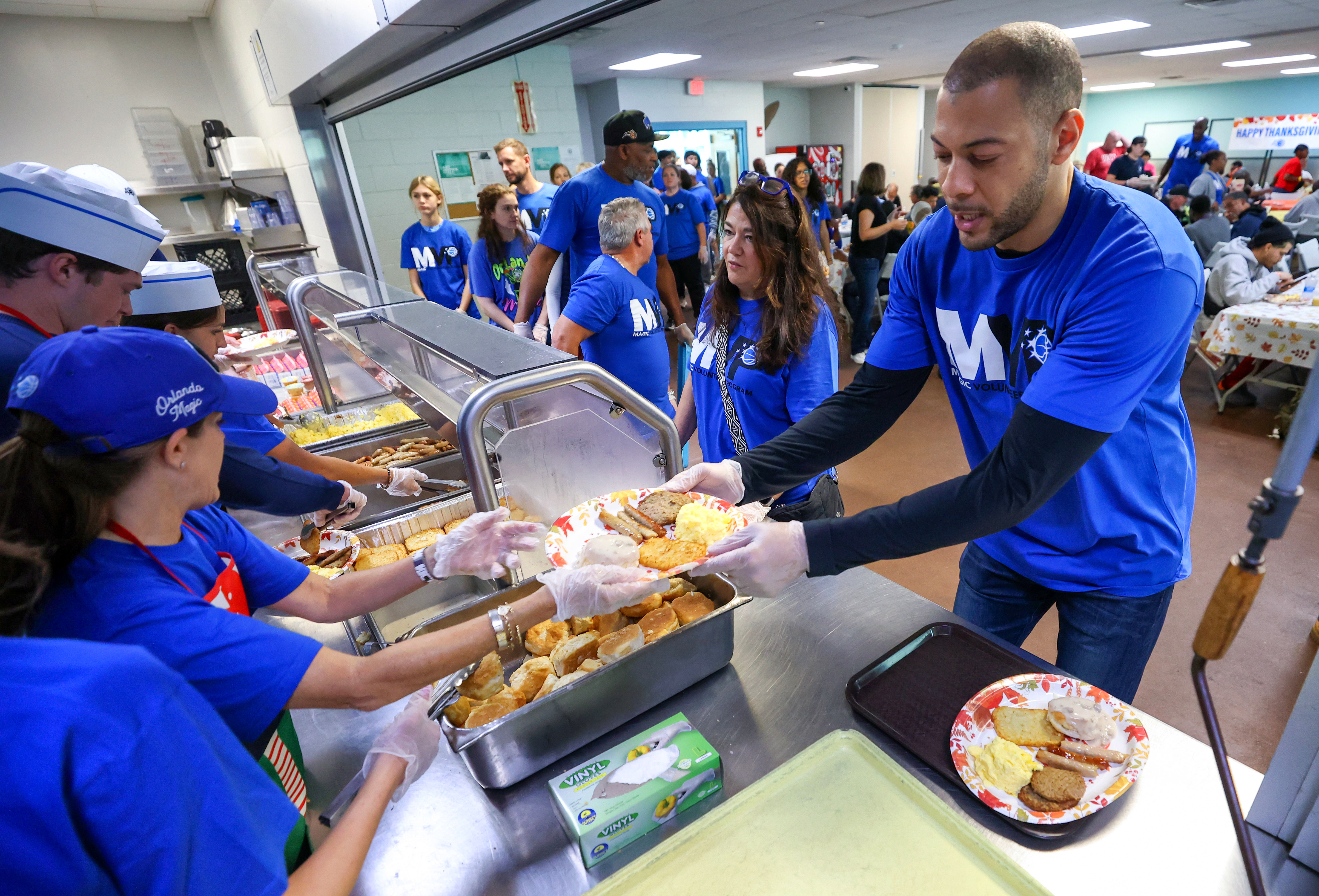 El gerente general del equipo, Anthony Parker, se prepara para servir en el 33º Desayuno Anual de Acción de Gracias del Orlando Magic en asociación con la Coalición para las Personas sin Hogar de Florida Central en su campus del centro de la ciudad el jueves por la mañana. (Joe Burbank/Orlando Sentinel)
