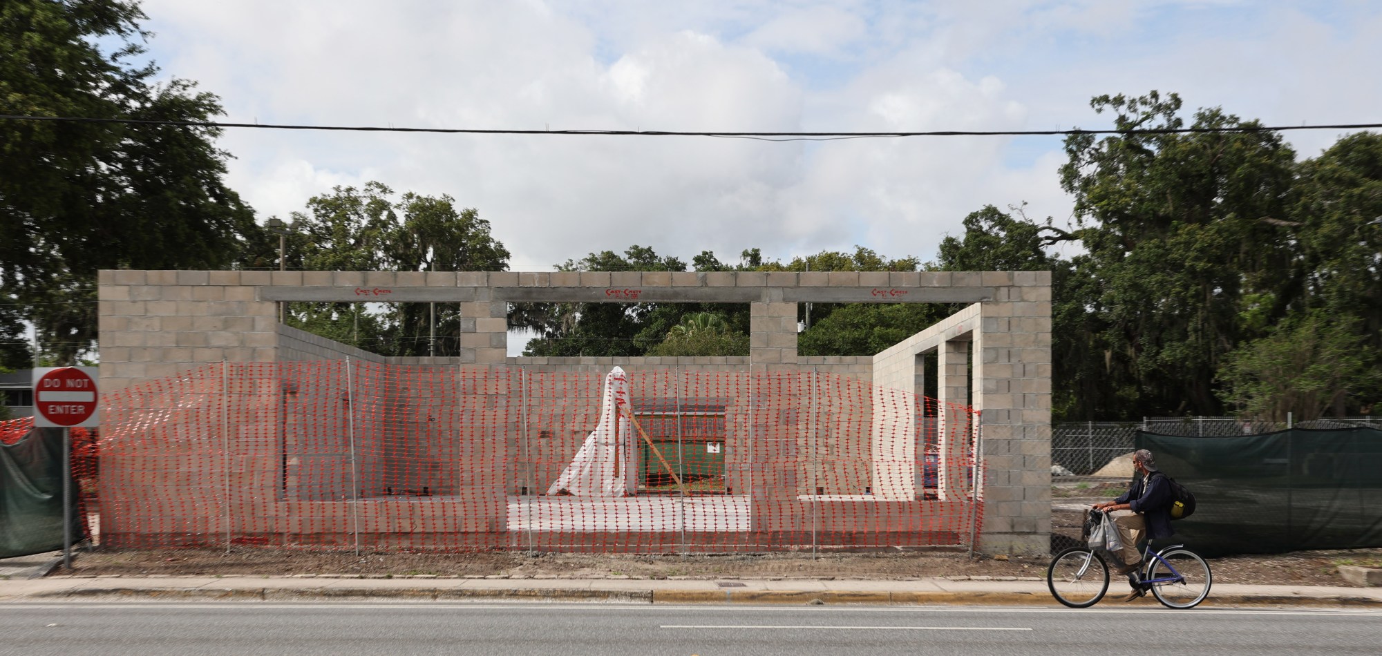 Un ciclista observa el sitio de construcción en 744 West Colonial Drive, el miércoles 4 de junio de 2025. La ciudad emitió una orden de suspensión de obras la semana pasada después de que el propietario demoliera el antiguo edificio de Burger King y comenzara la construcción sin permisos. El propietario es un conocido y galardonado chef que posee 3 restaurantes en Orlando y Winter Park. (Ricardo Ramírez Buxeda/Orlando Sentinel)