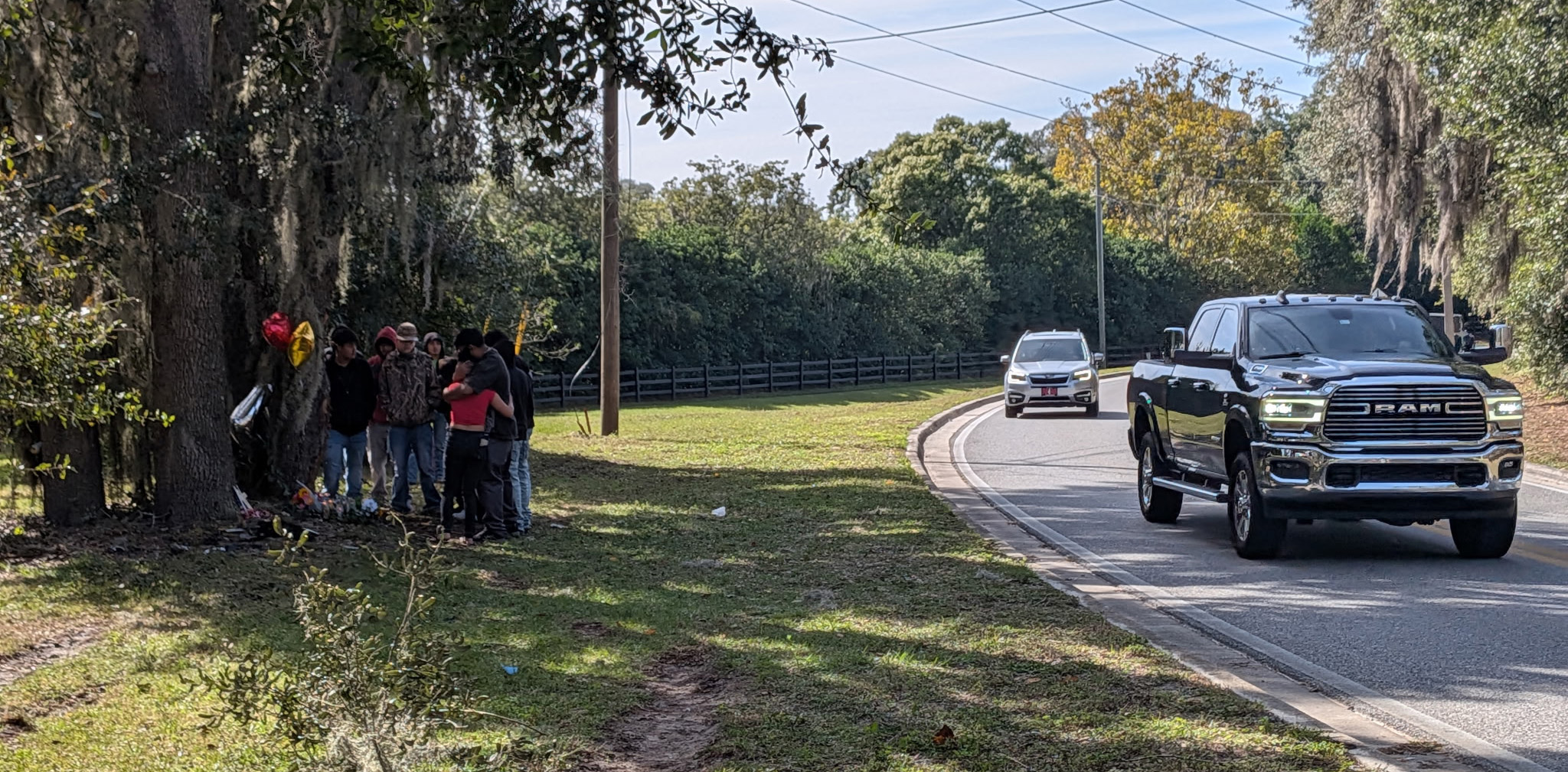 La gente se reúne el lunes 10 de noviembre de 2025 en Welch Drive y Wekiwa Drive en Apopka, el escenario de un accidente mortal que mató a tres adolescentes la madrugada del domingo 9 de noviembre de 2025. (Brian Bell/Orlando Sentinel)