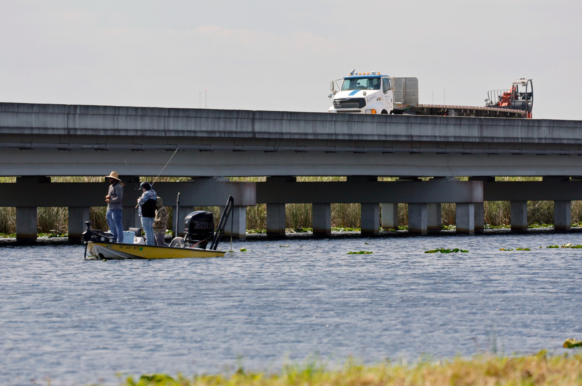 Pescadores en el agua mientras el tráfico pasa por la autopista estadounidense 41 en los Everglades en el puente de 1 milla el viernes 24 de febrero de 2023. Las praderas marinas de Florida, que alguna vez fueron algunas de las praderas más grandes del planeta, han estado muriendo a un ritmo alarmante. Parte del problema es la falta de agua dulce que fluye a través de los Everglades, lo que provoca la extinción de pastos marinos en la Bahía de Florida, los Cayos y 10.000 islas. La buena noticia: los nuevos puentes bajo el Tamiami Trail han aumentado el flujo de agua dulce hacia el Parque Nacional Everglades en un 80%. (Mike Stocker/Sun Sentinel del Sur de Florida)