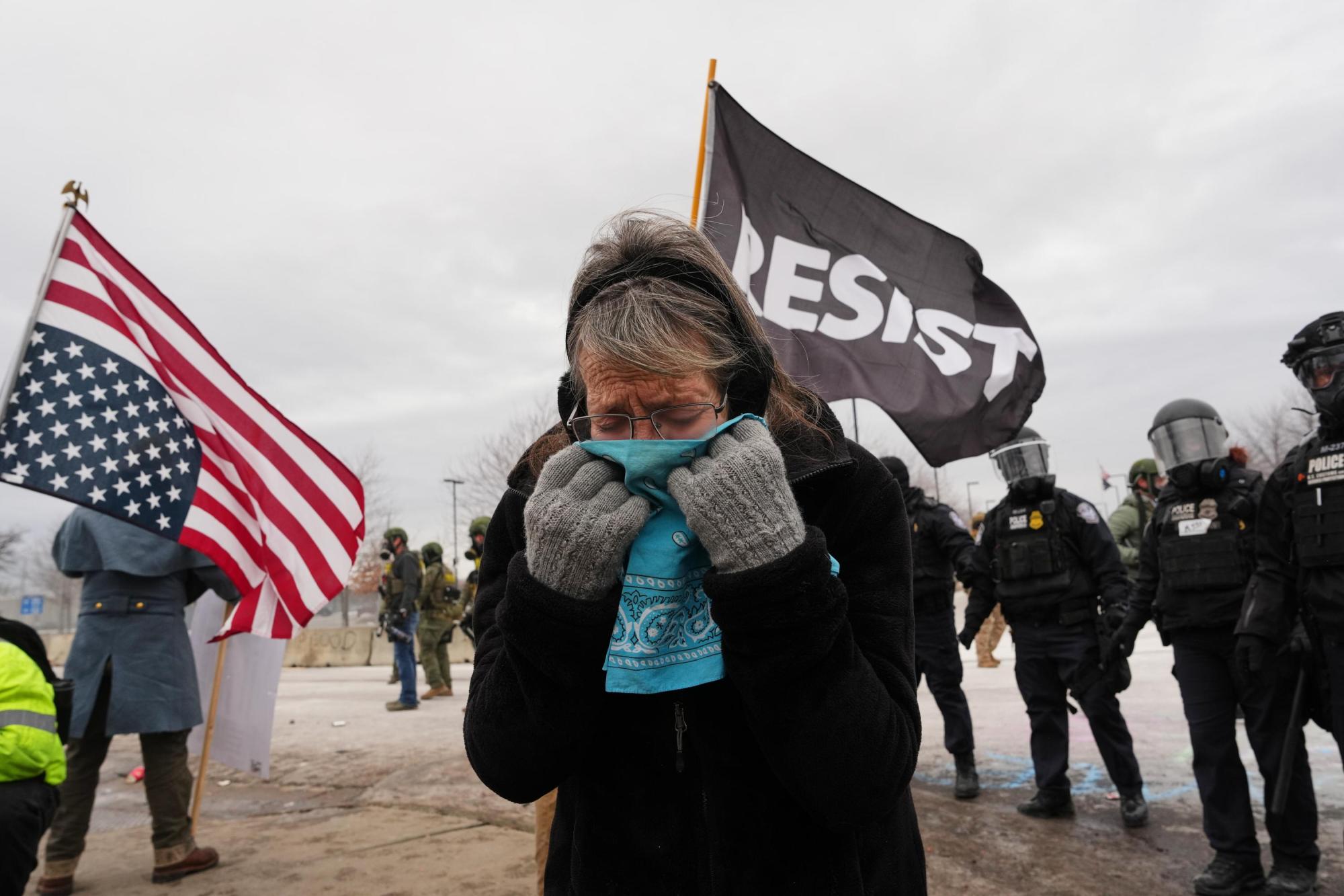 Una mujer se cubre la cara con gas lacrimógeno mientras agentes federales de inmigración se enfrentan a manifestantes frente al edificio federal Bishop Henry Whipple, el jueves 15 de enero de 2026, en Minneapolis. (Foto AP/Adam Gray)