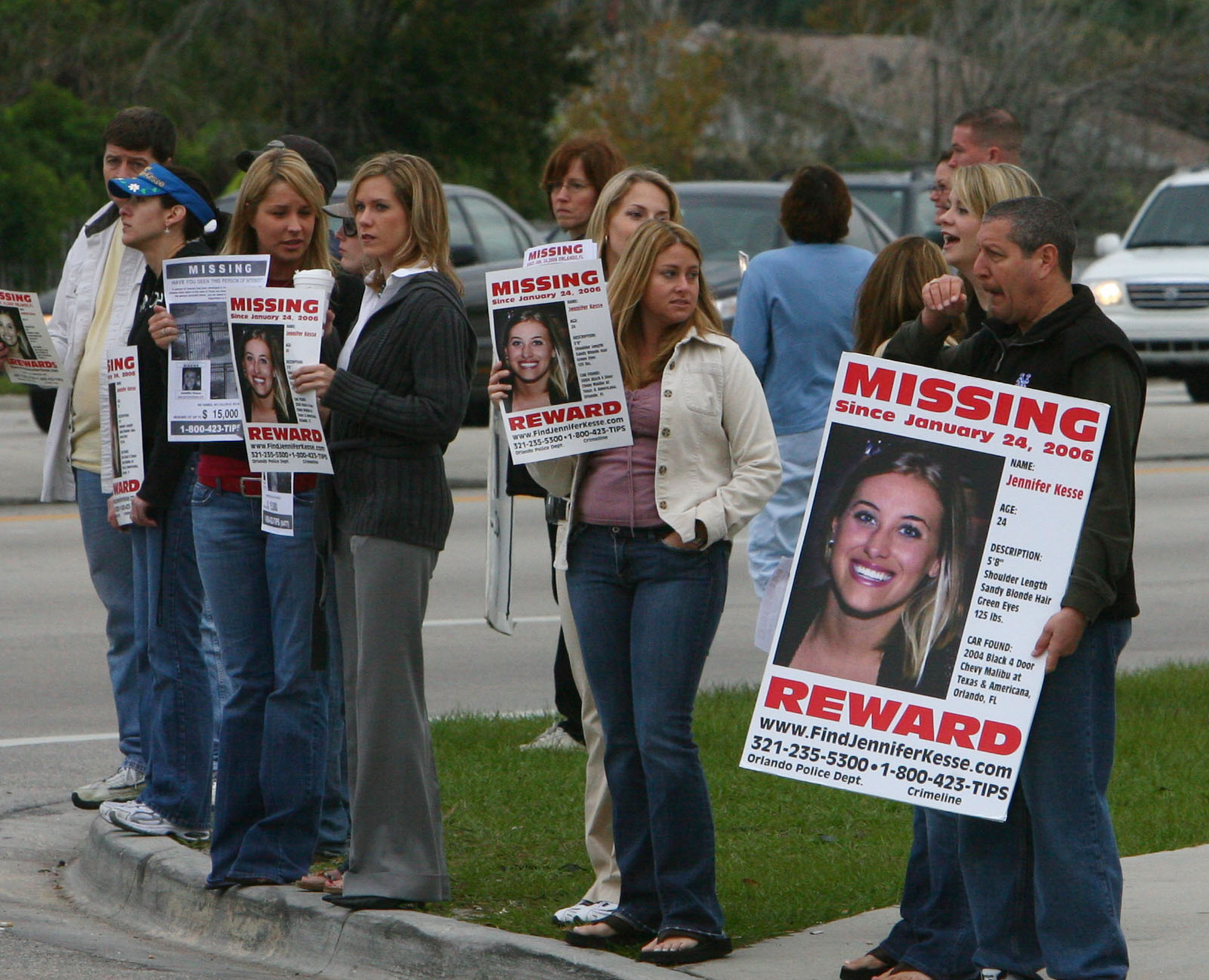 La gente se reúne sosteniendo carteles de personas desaparecidas el 24 de enero de 2007 de Jennifer Kesse en la esquina de John Young Parkway y Conroy Rd. Ha pasado un año desde la desaparición de Jennifer Kesse. (Red Huber/Orlando Sentinel)