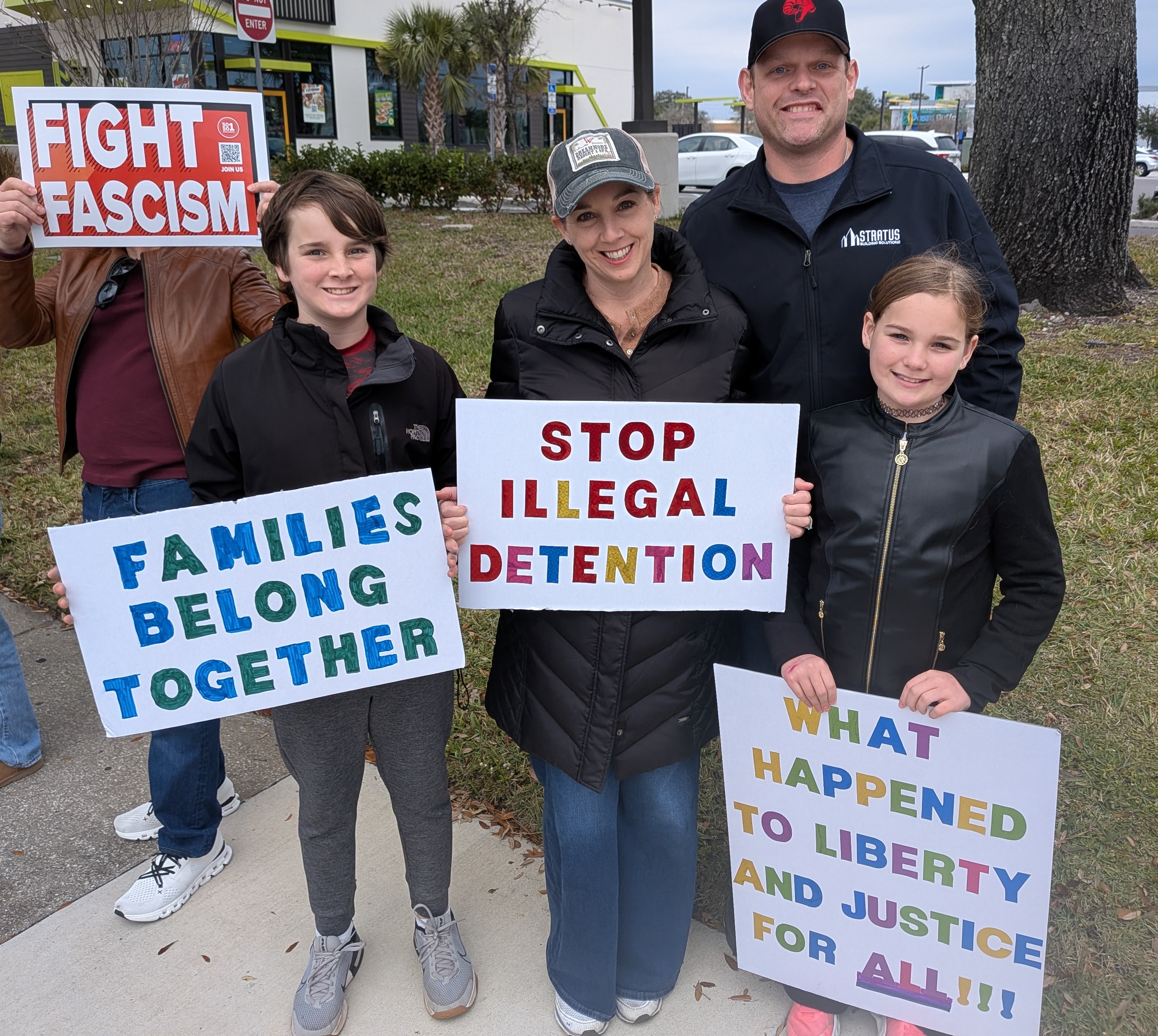 Una pareja llevó a su hijo de 11 años y a su hija de 9 a la protesta Ice Out of Orlando el sábado 31 de enero de 2026, a lo largo de East Colonial Drive, cerca del Fashion Square Mall. Los padres dijeron que sentían que era importante que sus hijos aprendieran sobre lo que está sucediendo en la nación experimentándolo de primera mano. (Brian Bell/Orlando Sentinel)