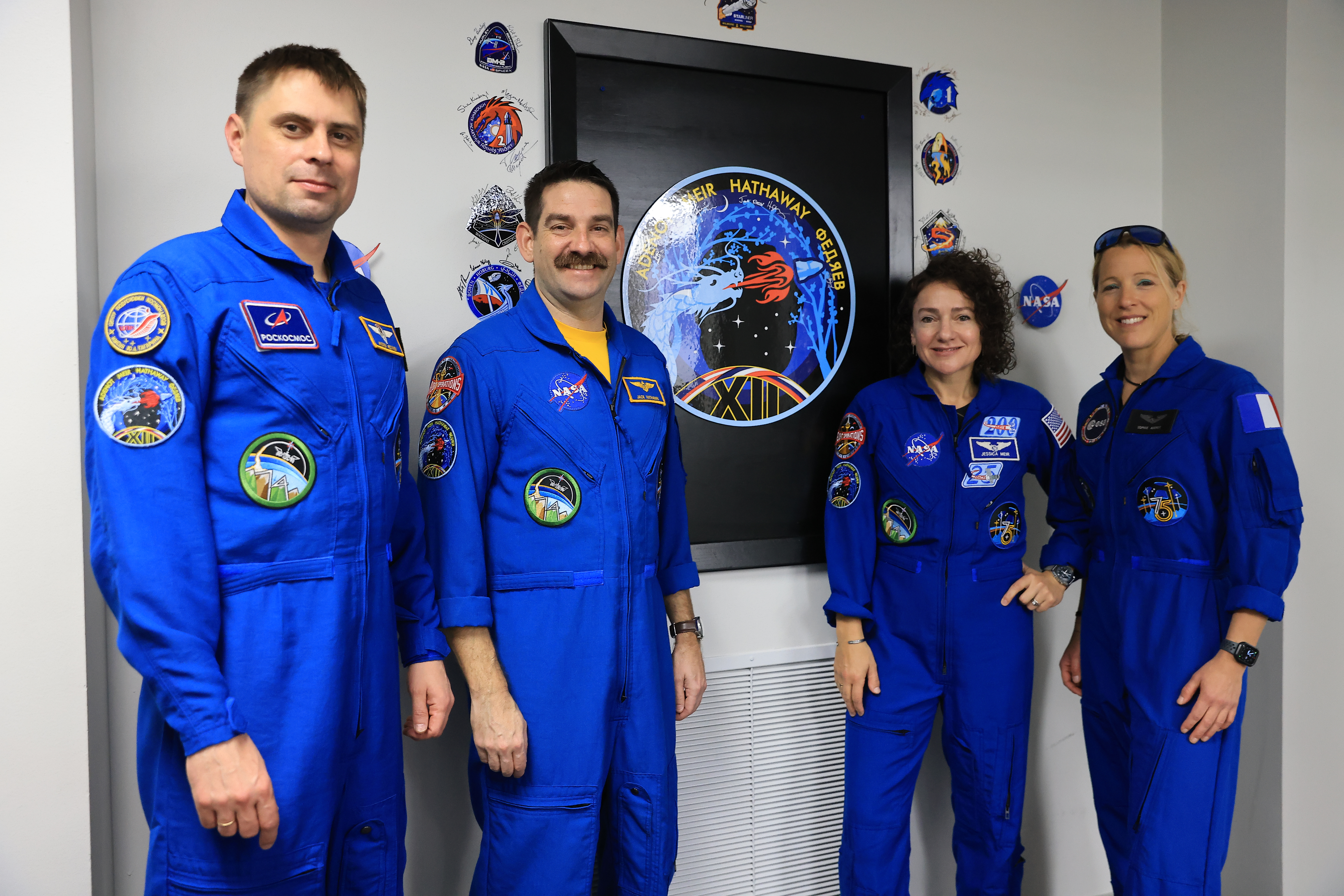Desde la izquierda, el cosmonauta de Roscosmos Andrey Fedyaev, los astronautas de la NASA Jack Hathaway y Jessica Meir, y la astronauta de la ESA (Agencia Espacial Europea) Sophie Adenot posan junto a la insignia de su misión dentro de los cuartos de la tripulación de astronautas en el edificio de operaciones y pago Neil A. Armstrong en el Centro Espacial Kennedy de la NASA en Florida el lunes 9 de febrero de 2026. Los miembros de la tripulación SpaceX Crew-12 de la NASA se lanzarán a bordo de una nave espacial SpaceX Dragon y Falcon 9 a la Internacional Estación Espacial no antes de las 5:15 am EST del viernes 13 de febrero, desde el Complejo de Lanzamiento Espacial 40 de la Estación de la Fuerza Espacial de Cabo Cañaveral. (Kim Shiflett/NASA)