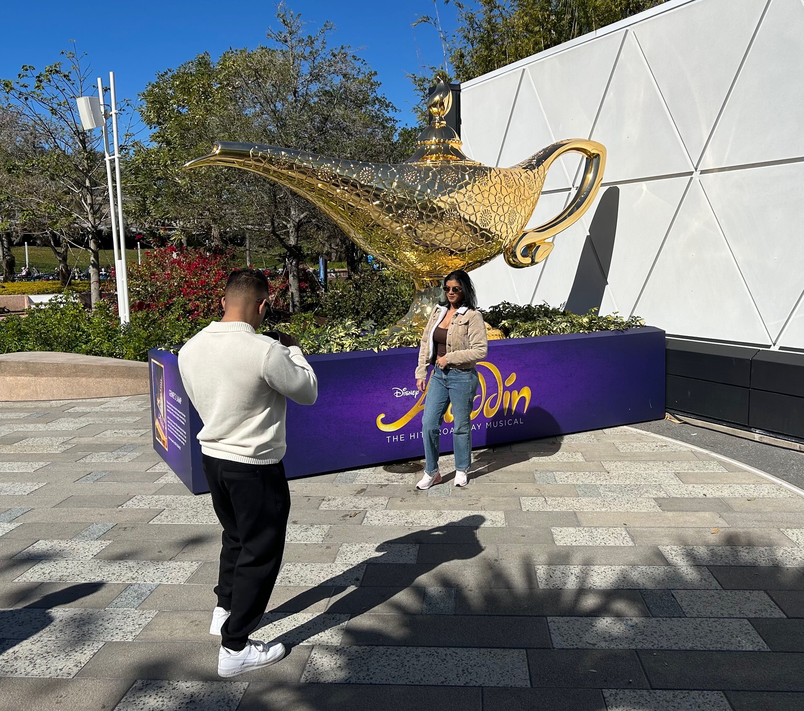 Los visitantes de Walt Disney World observan una lámpara Genie de gran tamaño vista en el Festival Internacional de las Artes de Epcot 2026. La figura dorada una vez estuvo encima de la marquesina del teatro de Broadway donde se presentó 'Aladdin'. (Dewayne Bevil/Orlando Sentinel)