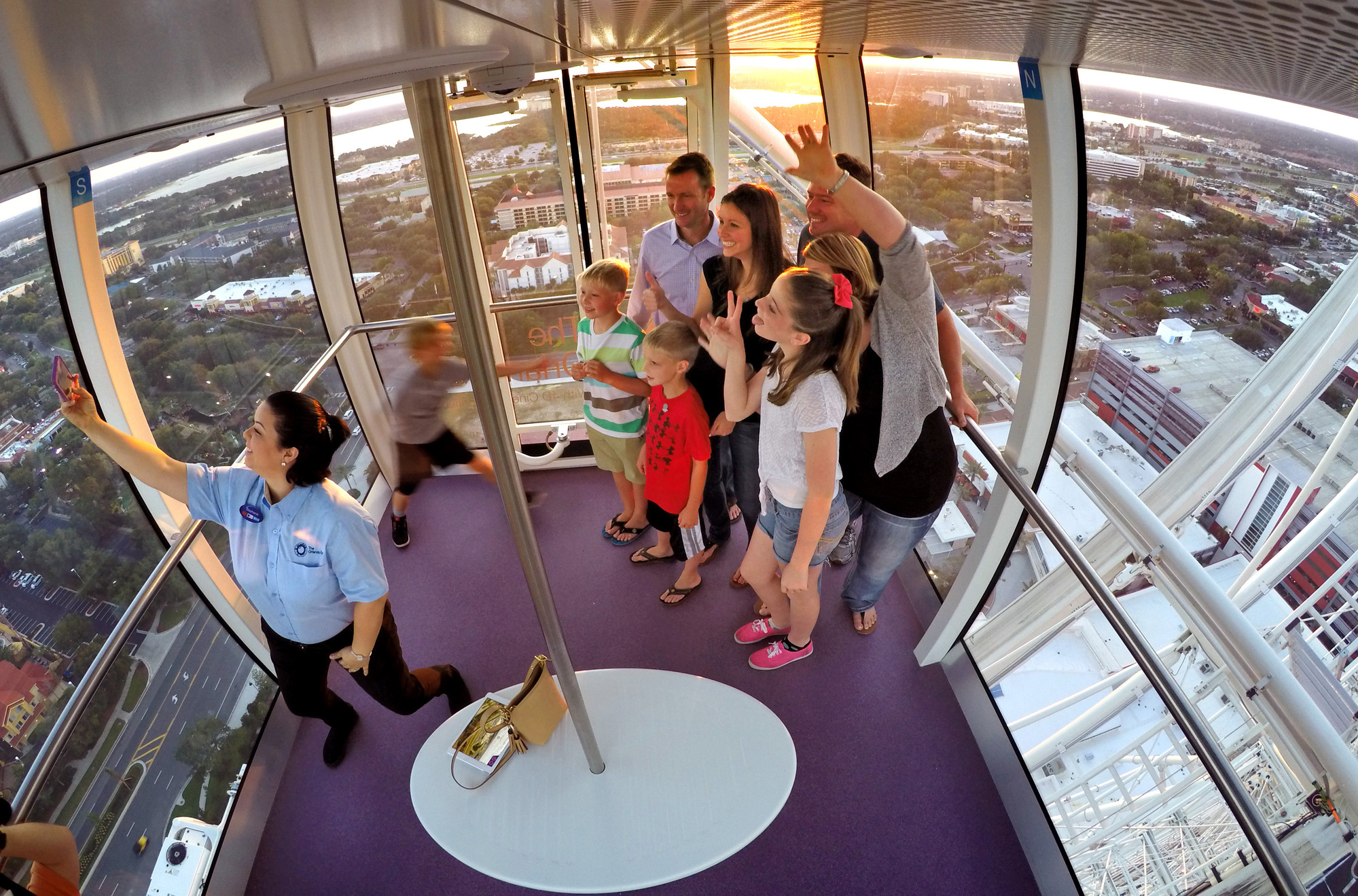 El azafato de la cápsula se toma una selfie con los pasajeros durante un paseo al atardecer en una de las cápsulas del Orlando Eye en el complejo I-Drive 360 el 1 de mayo de 2015. (Archivo Joe Burbank/Orlando Sentinel)