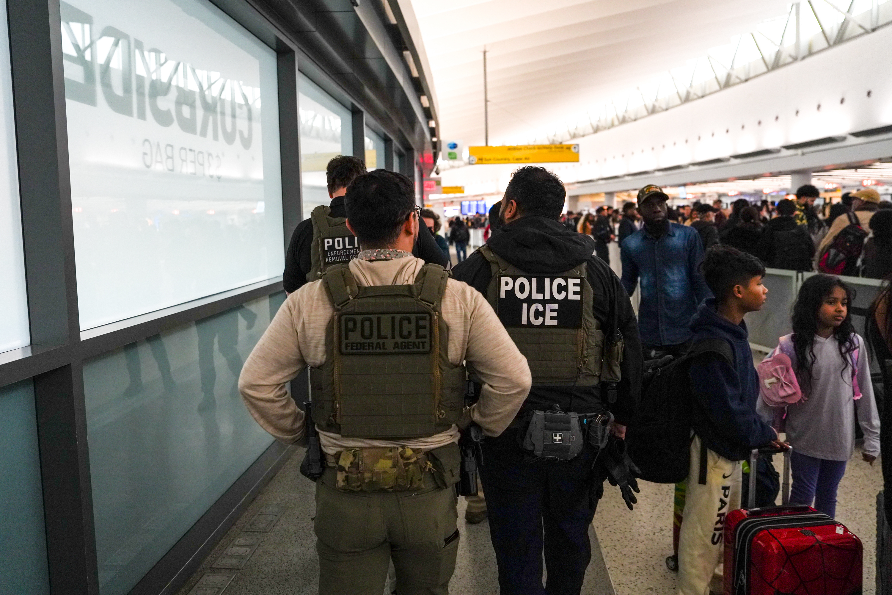 Agentes federales de inmigración caminan por la Terminal 5 en John F....