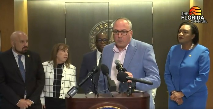 Michael Rajner analiza el Programa de Asistencia para Medicamentos contra el SIDA en una conferencia de prensa frente a la cámara del Senado de Florida el 25 de febrero de 2026. Escuchando desde la izquierda: el representante estatal Mitch Rosenwald, la líder demócrata del Senado, Lori Berman, la senadora estatal Shevrin Jones y la líder demócrata de la Cámara de Representantes, Fentrice Driskell. (Canal Florida/cortesía)