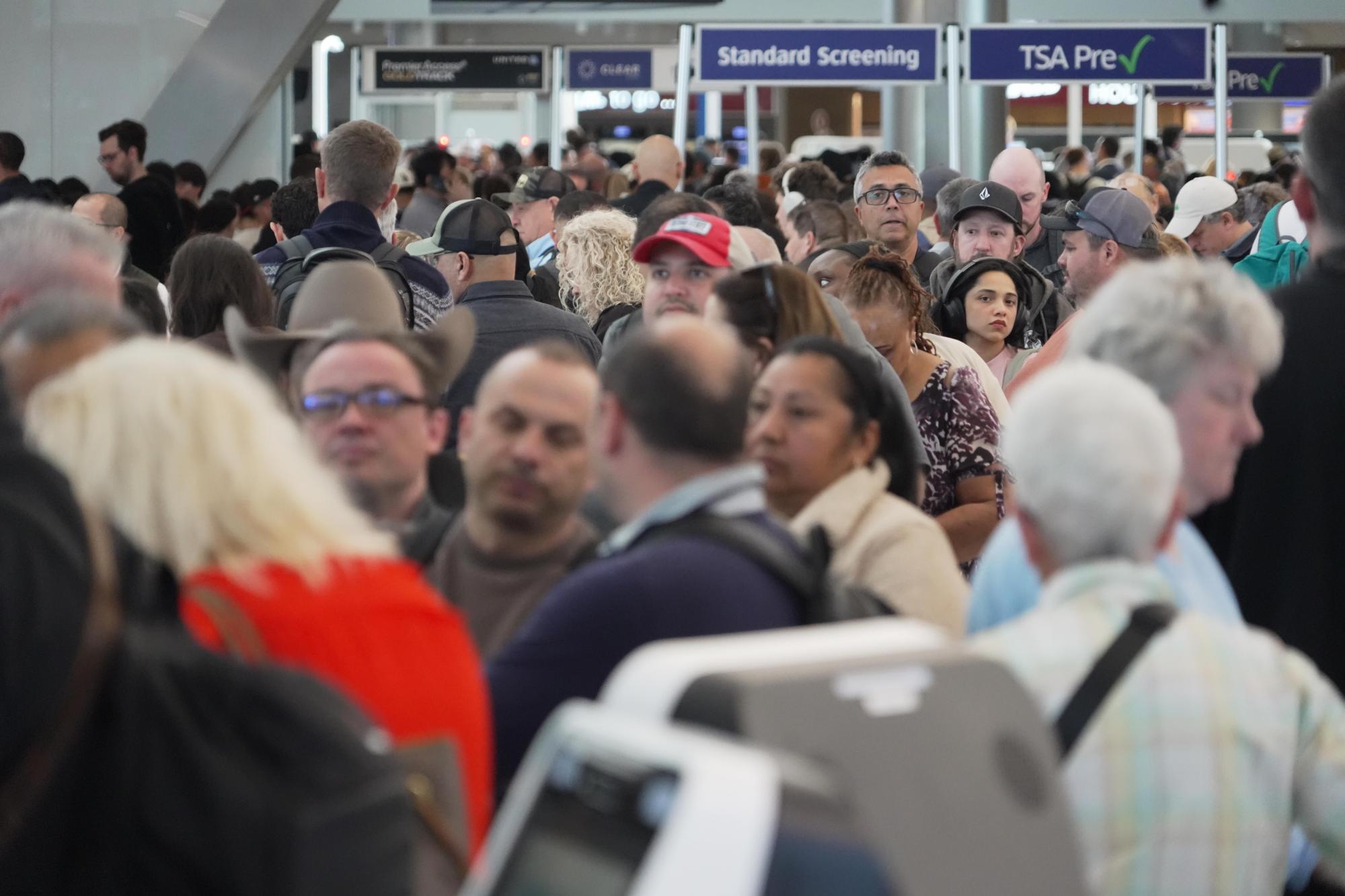 Los pasajeros de aerolíneas esperan en largas filas para pasar el control de seguridad de la TSA en el Aeropuerto Intercontinental George Bush en Houston el miércoles 18 de marzo de 2026. (Foto AP/Lekan Oyekanmi)