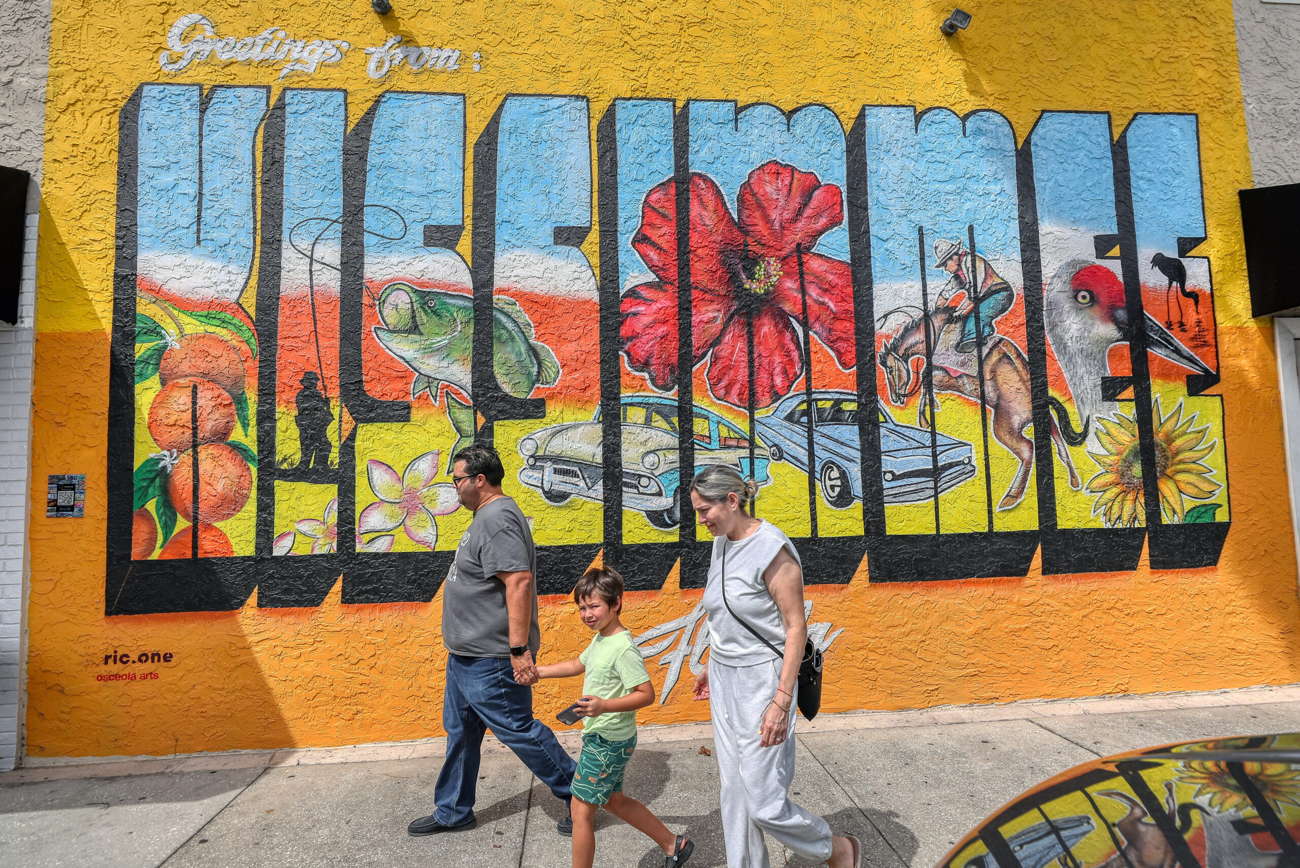 Los transeúntes pasan junto al artista Ric.One's 