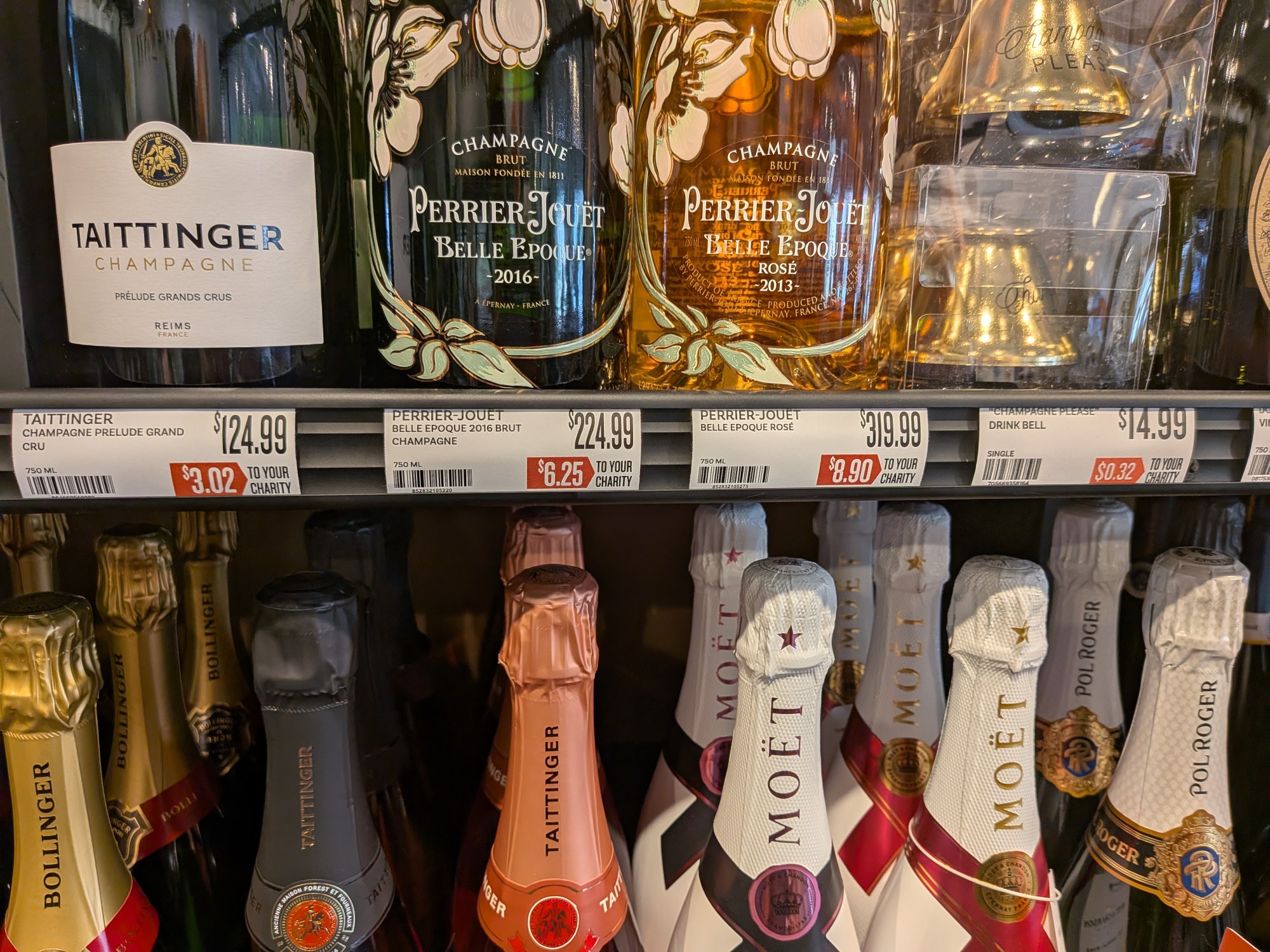 Las etiquetas de los estantes de algunos de los mejores champagnes disponibles en la tienda The Good Pour en Winter Park, vistas el jueves 16 de abril de 2025, muestran más que el precio. El monto en el cuadro rojo muestra cuánto de ese precio de compra terminará yendo a parar a las más de 250 organizaciones benéficas y sin fines de lucro que apoya la creciente cadena. (Brian Bell/Orlando Sentinel)