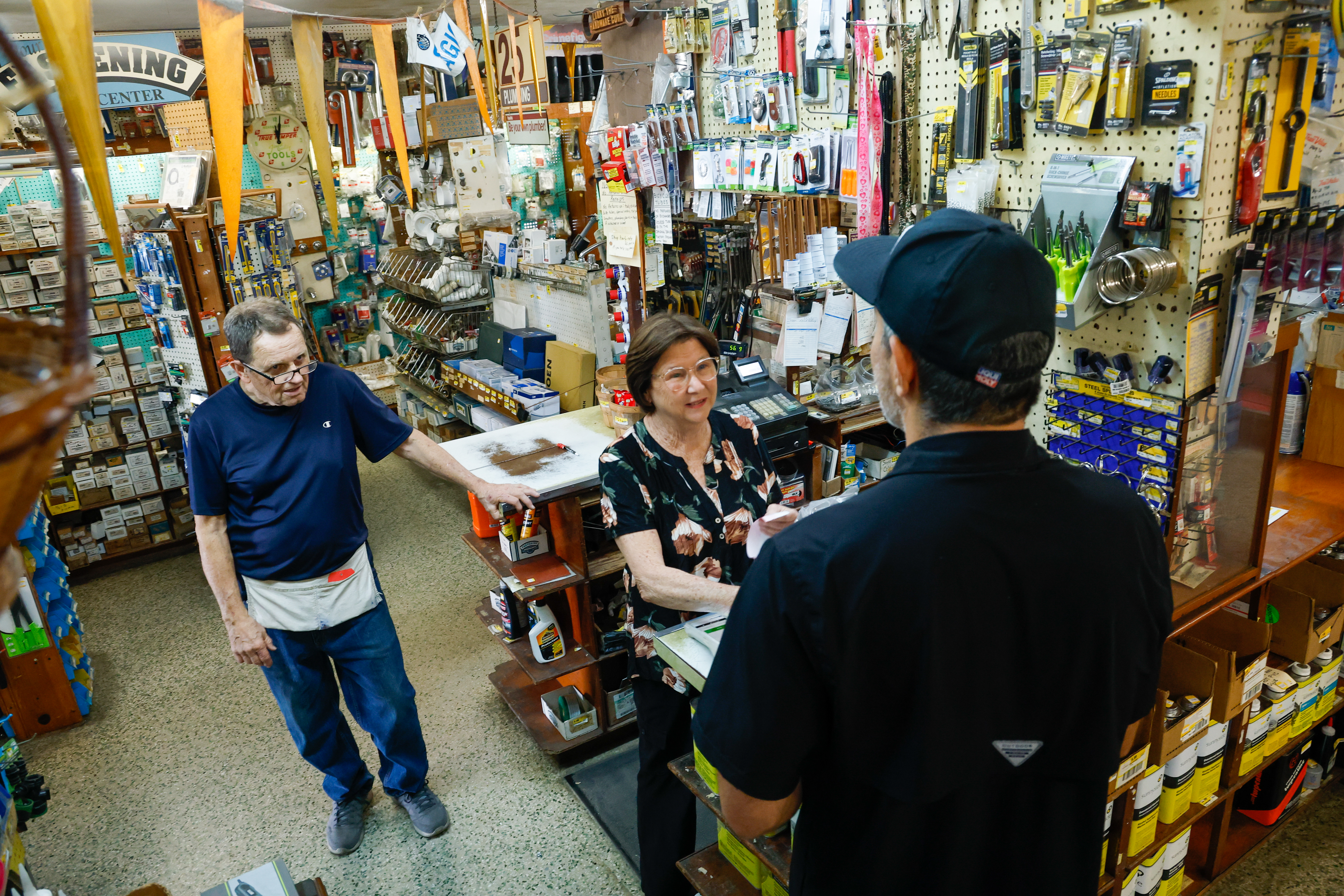 Belinda y Larry Finley, antiguos propietarios de J&L Hardware en Orlando, hablan con el cliente Mario Dias mientras paga un artículo. La pareja se jubilará y cerrará la tienda, que ha estado en funcionamiento en Orange Blossom Trail desde la década de 1970. (Papa rico/Orlando Sentinel)