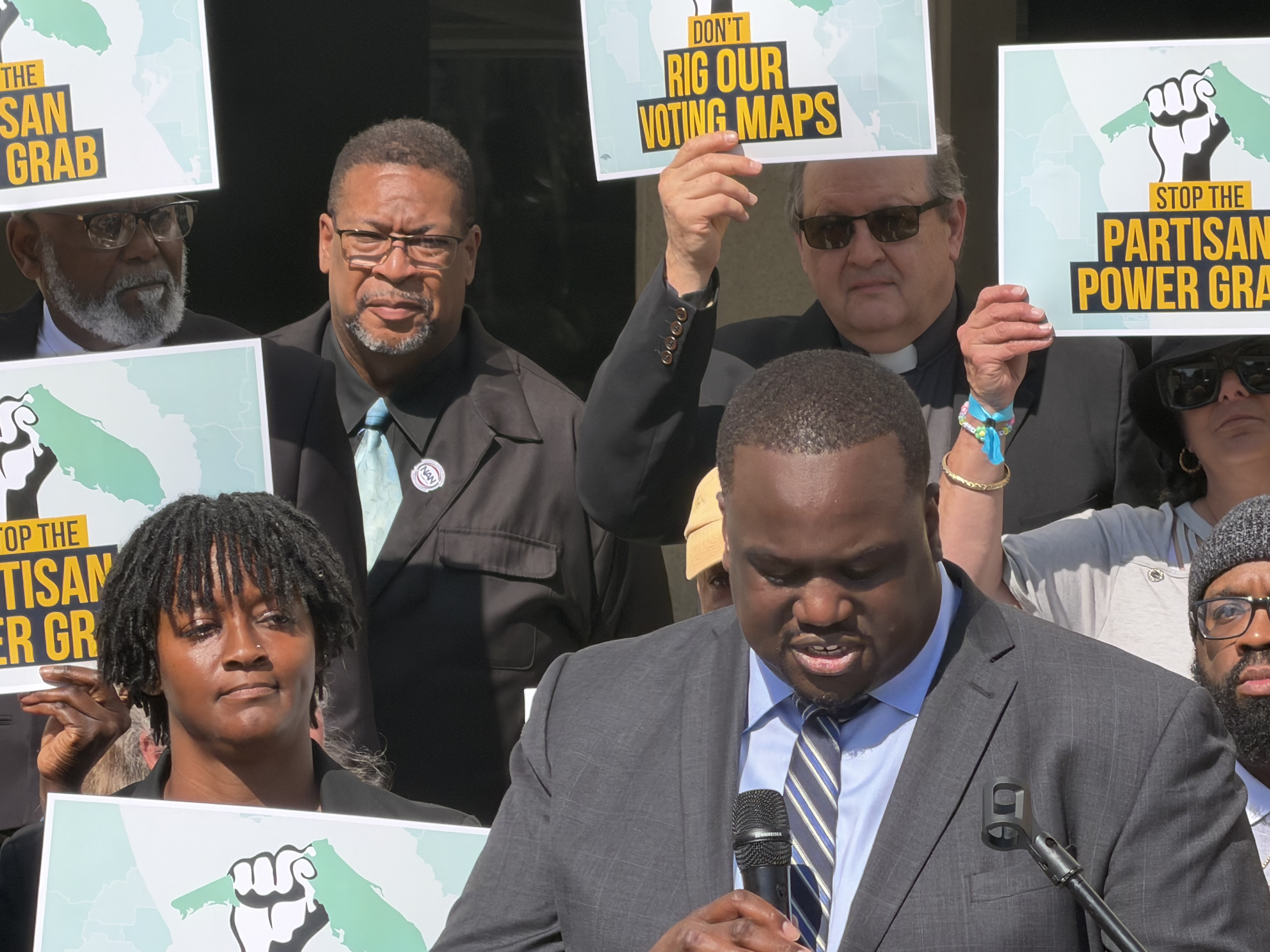 Genesis Robinson, cofundador de Equal Ground, habla ante una multitud de manifestantes reunidos en el Capitolio estatal el martes 28 de abril de 2026. Alrededor de 200 personas se presentaron el día inaugural de una sesión especial para protestar contra el nuevo mapa de redistribución de distritos del gobernador Ron DeSantis que elimina cuatro escaños demócratas, incluido un escaño de mayoría hispana en el condado de Osceola. (Jeffrey Schweers/Orlando Sentinel)