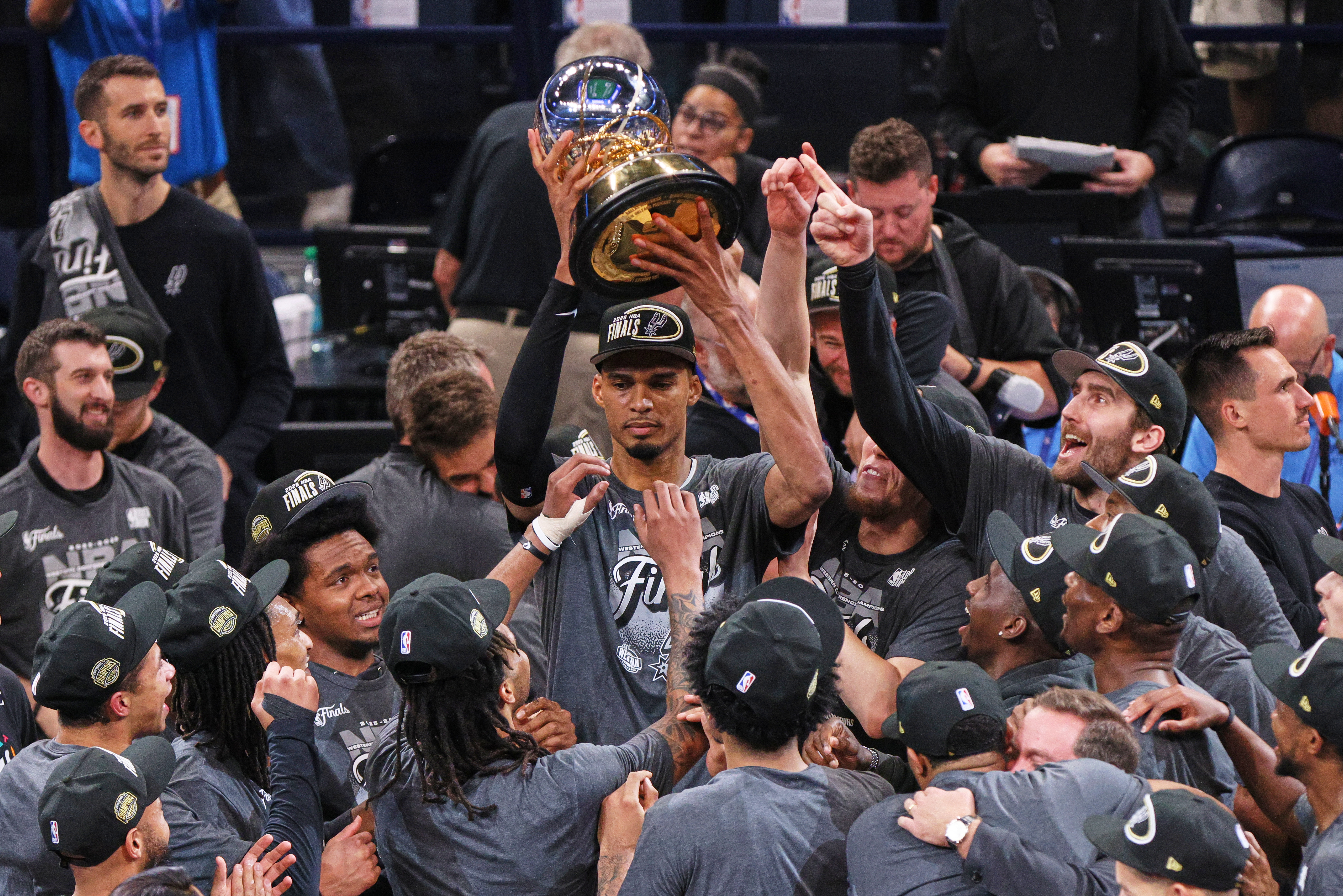 El pívot de los San Antonio Spurs, Victor Wembanyama, sostiene el Trofeo Oscar Robertson después de derrotar al Oklahoma City Thunder en las Finales de la Conferencia Oeste el sábado por la noche. (Foto AP/Nate Billings)