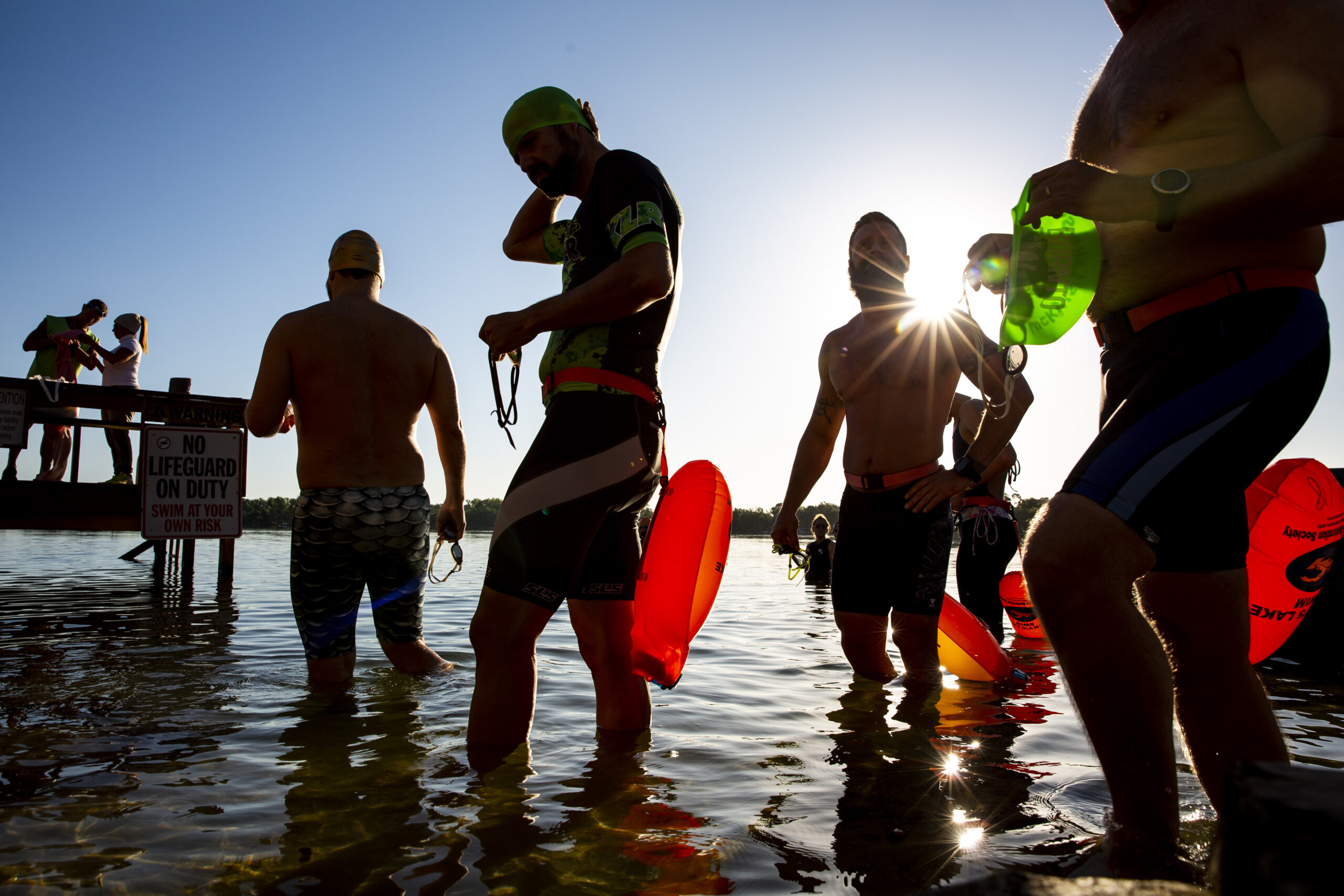 Los nadadores ingresan al agua del lago Cane durante el noveno evento anual Easter Eat, Pray, Swim en Lucky's Lake Swim en Orlando el domingo 21 de abril de 2019. (Patrick Connolly/Orlando Sentinel)