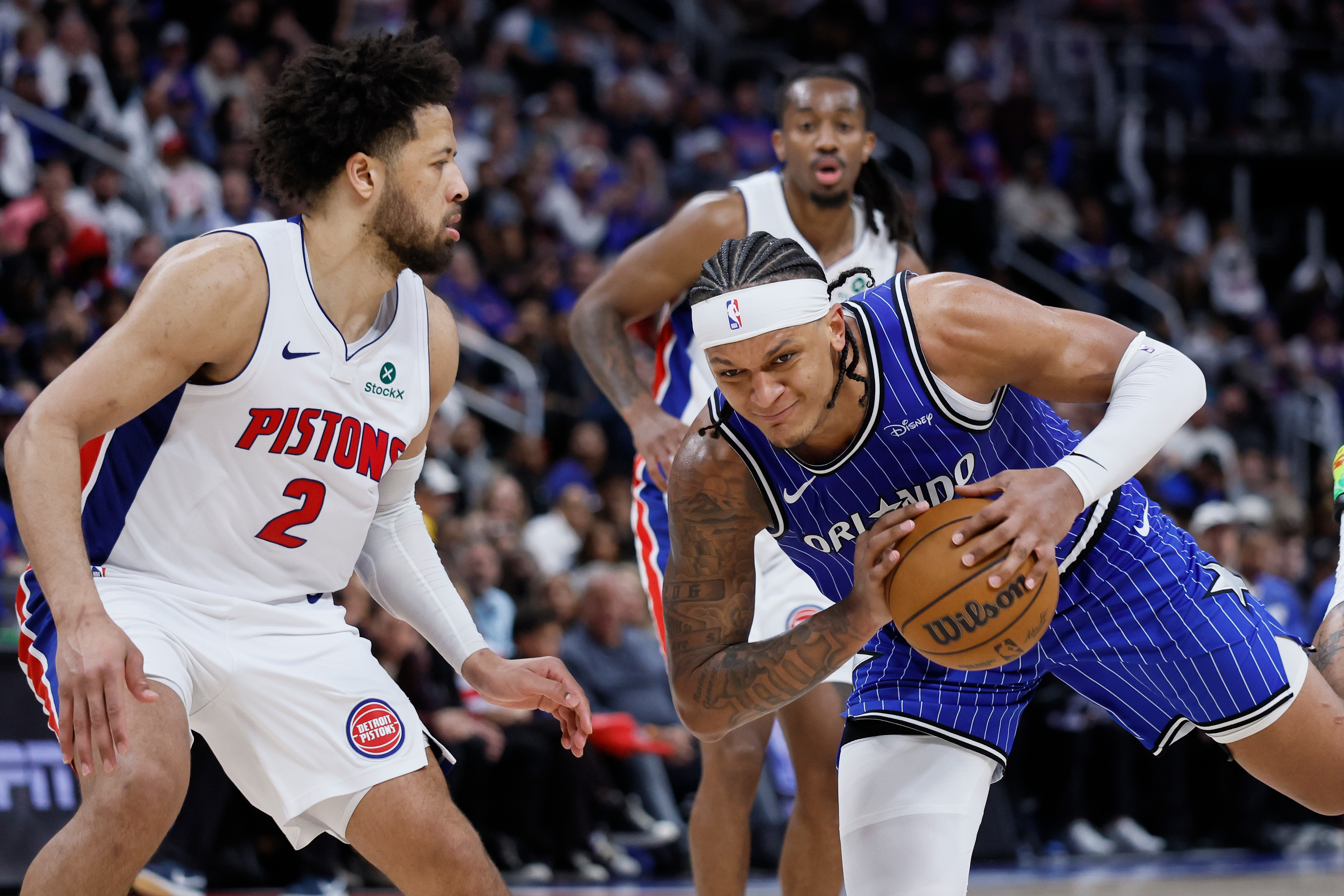 El delantero del Magic Paolo Banchero, derecha, pasa el balón contra el guardia de los Pistons, Cade Cunningham (2), durante la segunda mitad del Juego 7 el domingo en Detroit. (Foto AP/Duane Burleson)