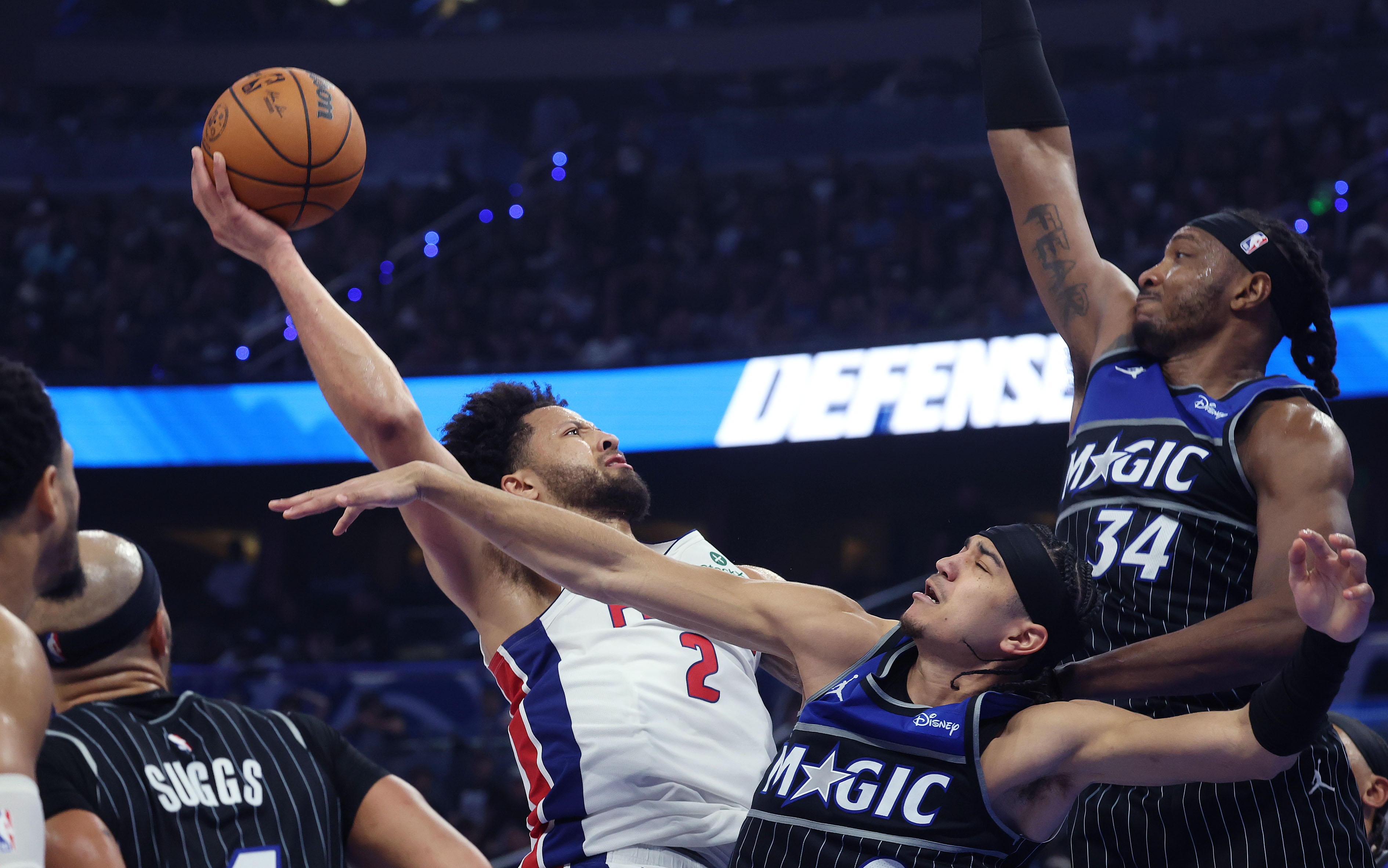 El guardia de los Pistons, Cade Cunningham (2), supera al guardia del Magic, Anthony Black (abajo) y al centro de Orlando, Wendell Carter Jr. (34), durante el Juego 6 del viernes dentro del Kia Center. (Stephen M. Dowell/Orlando Sentinel)